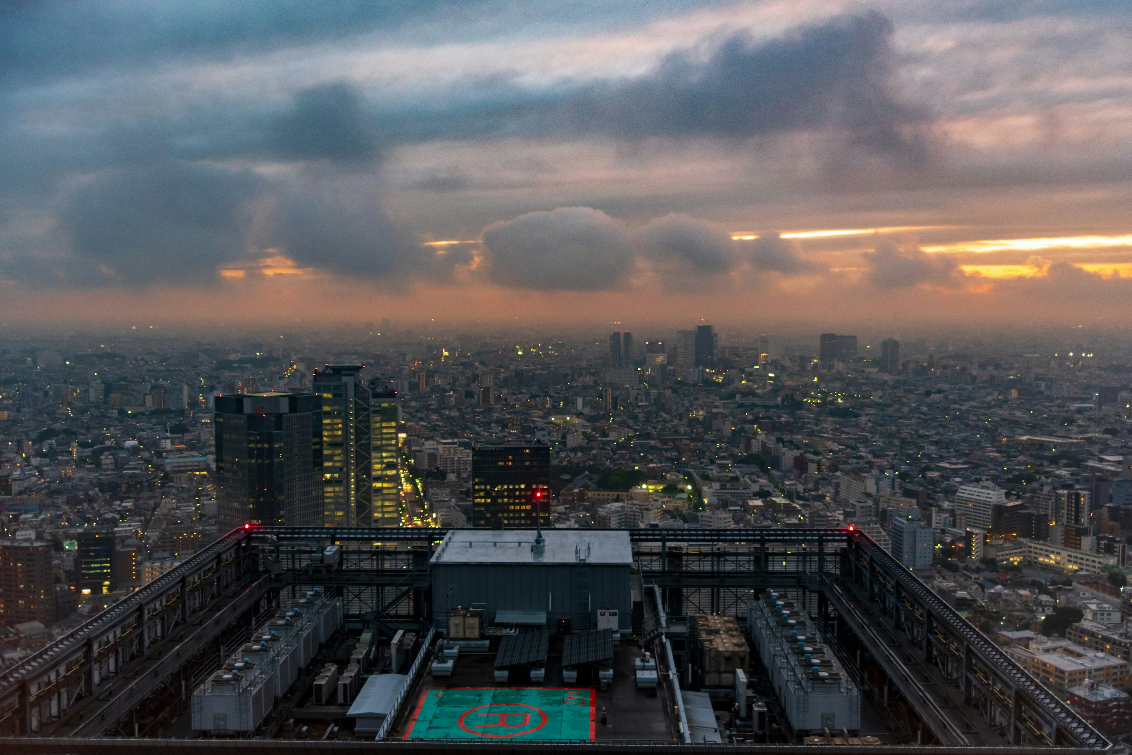 Vista del atardecer desde un rascacielos en Tokio con edificios y nubes