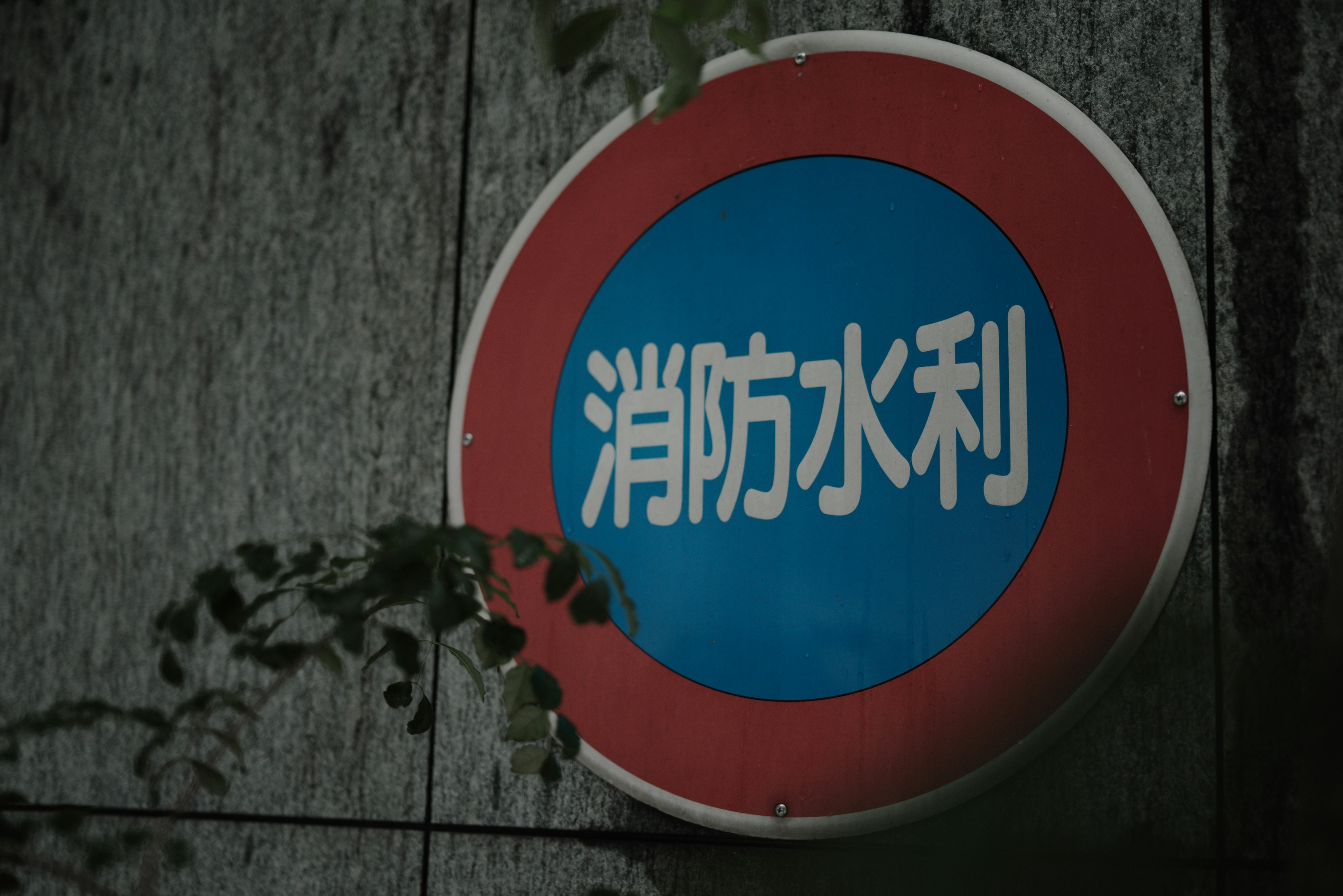 A round sign with red and blue colors displaying fire hydrant information in white text