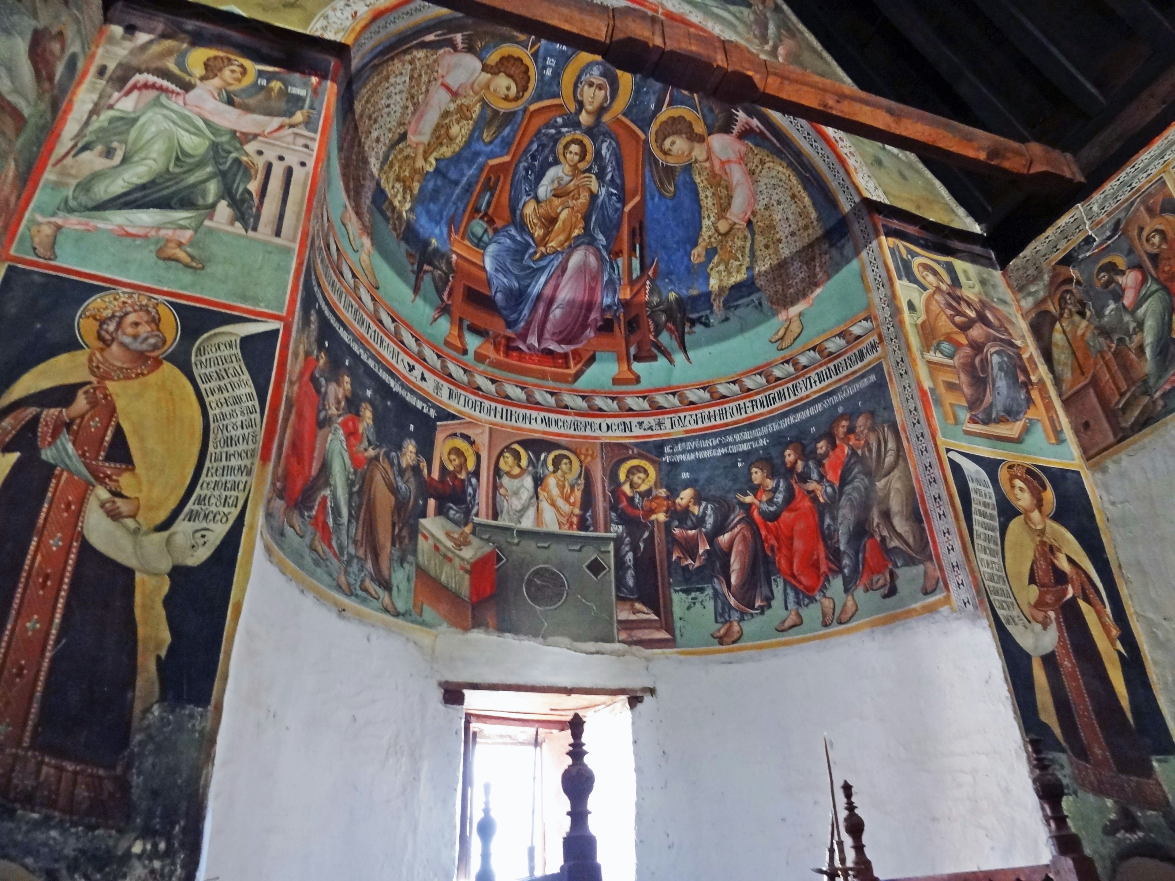 Vista interior de una iglesia adornada con hermosos frescos que representan a la Virgen María y a Cristo