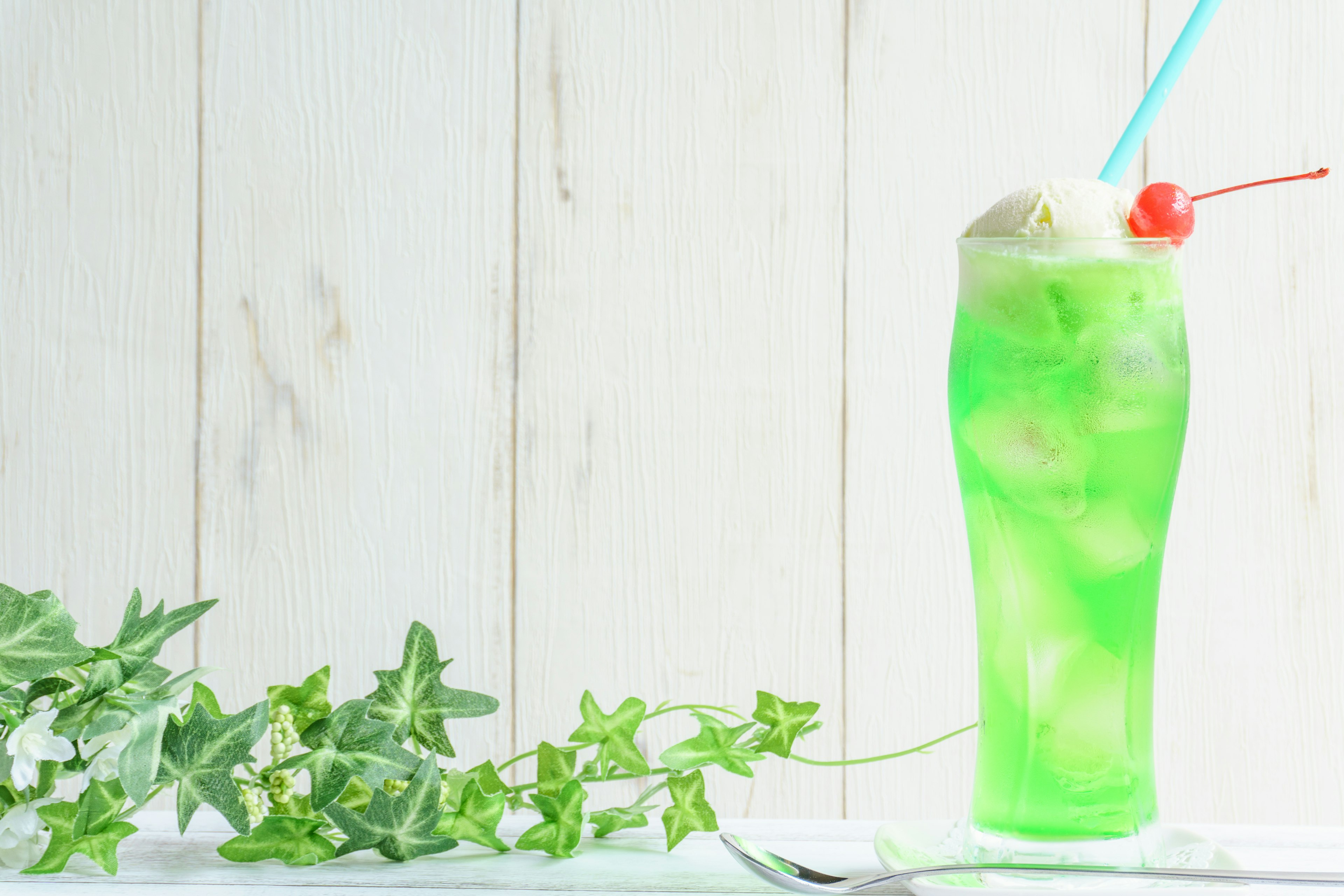 Image of a green drink topped with ice cream in a tall glass