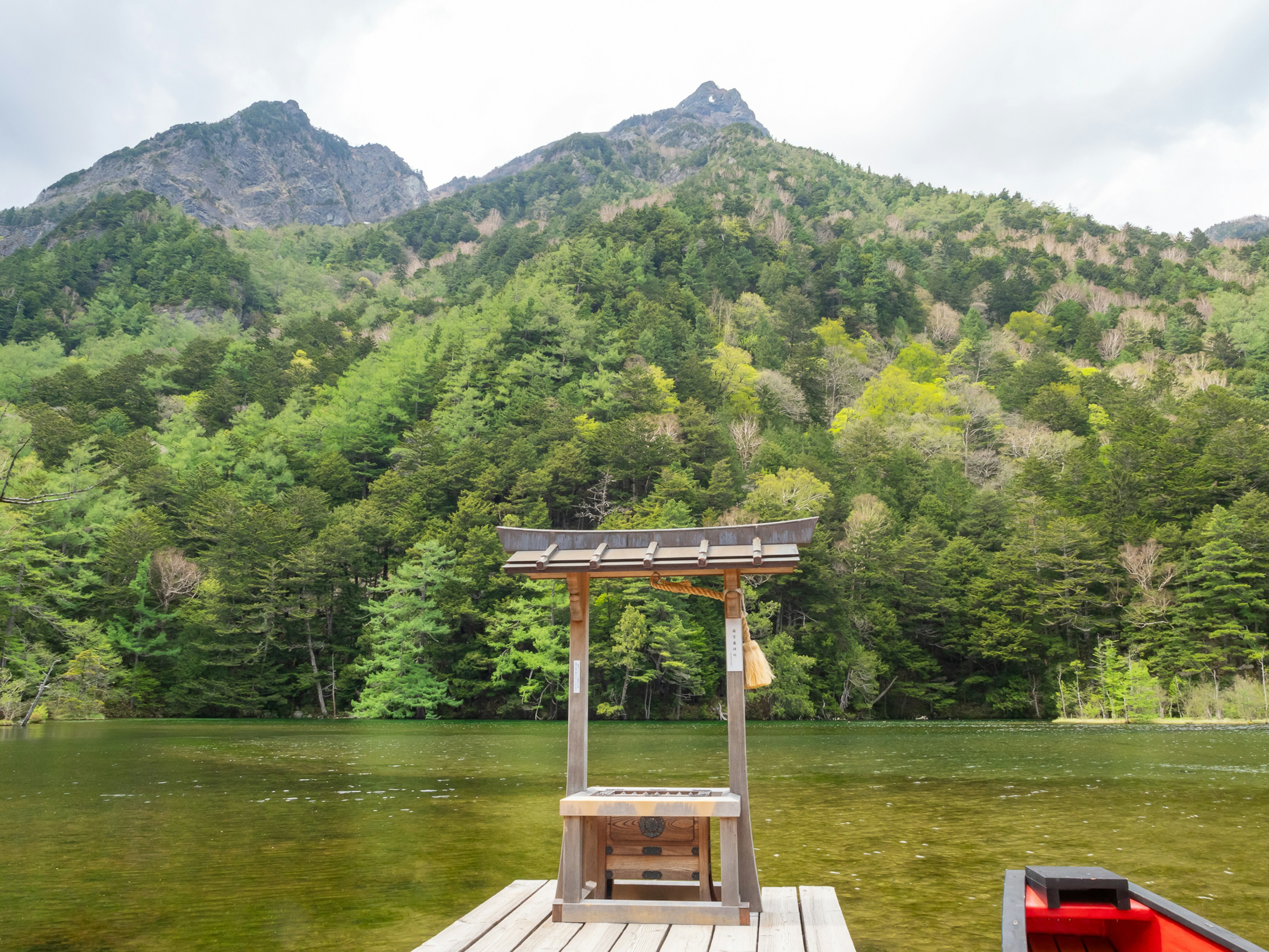 静かな湖と緑豊かな山々の風景 船着き場が水面に浮かぶ