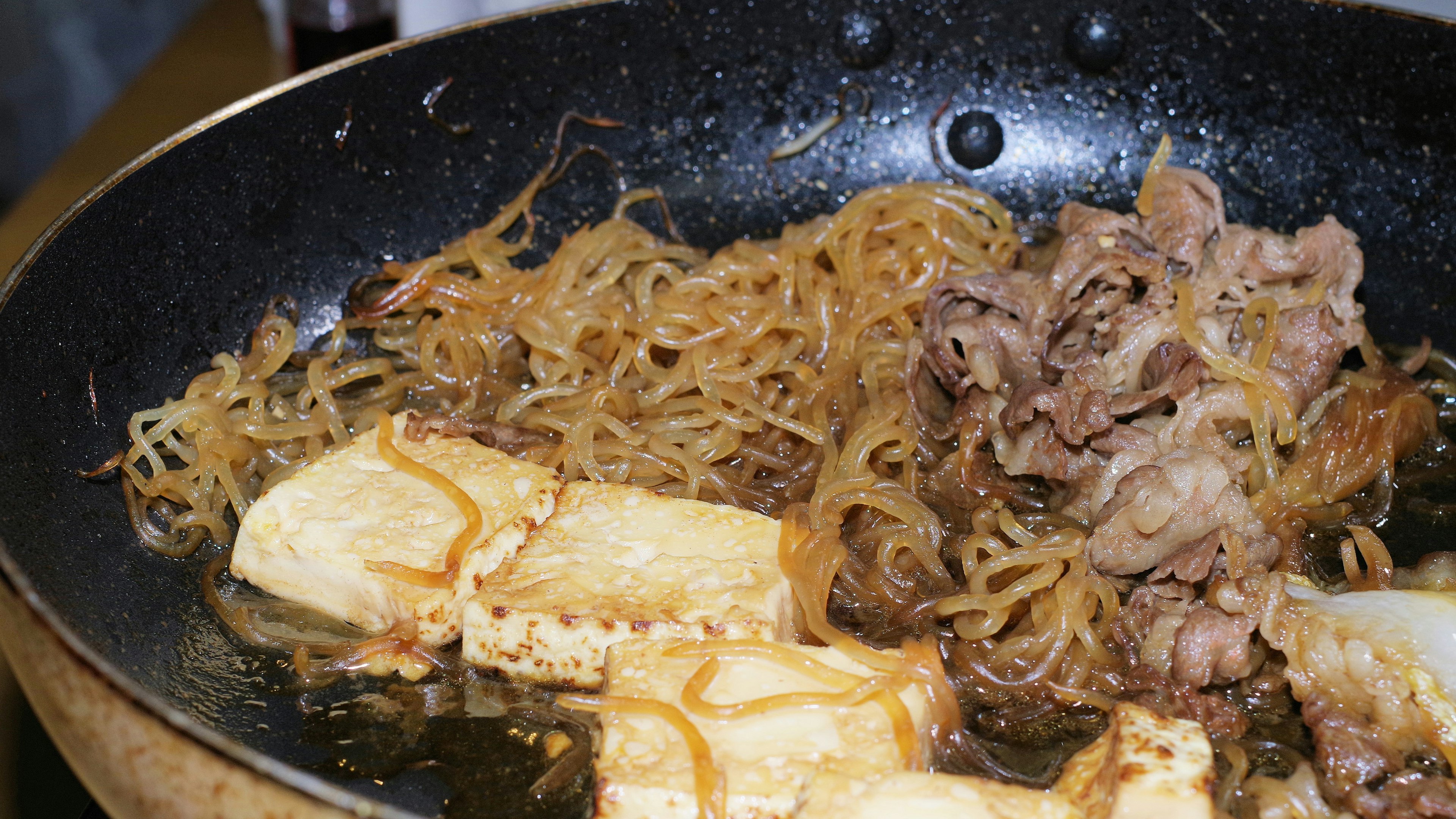 鍋の中に盛り付けられた焼き豆腐と肉の料理