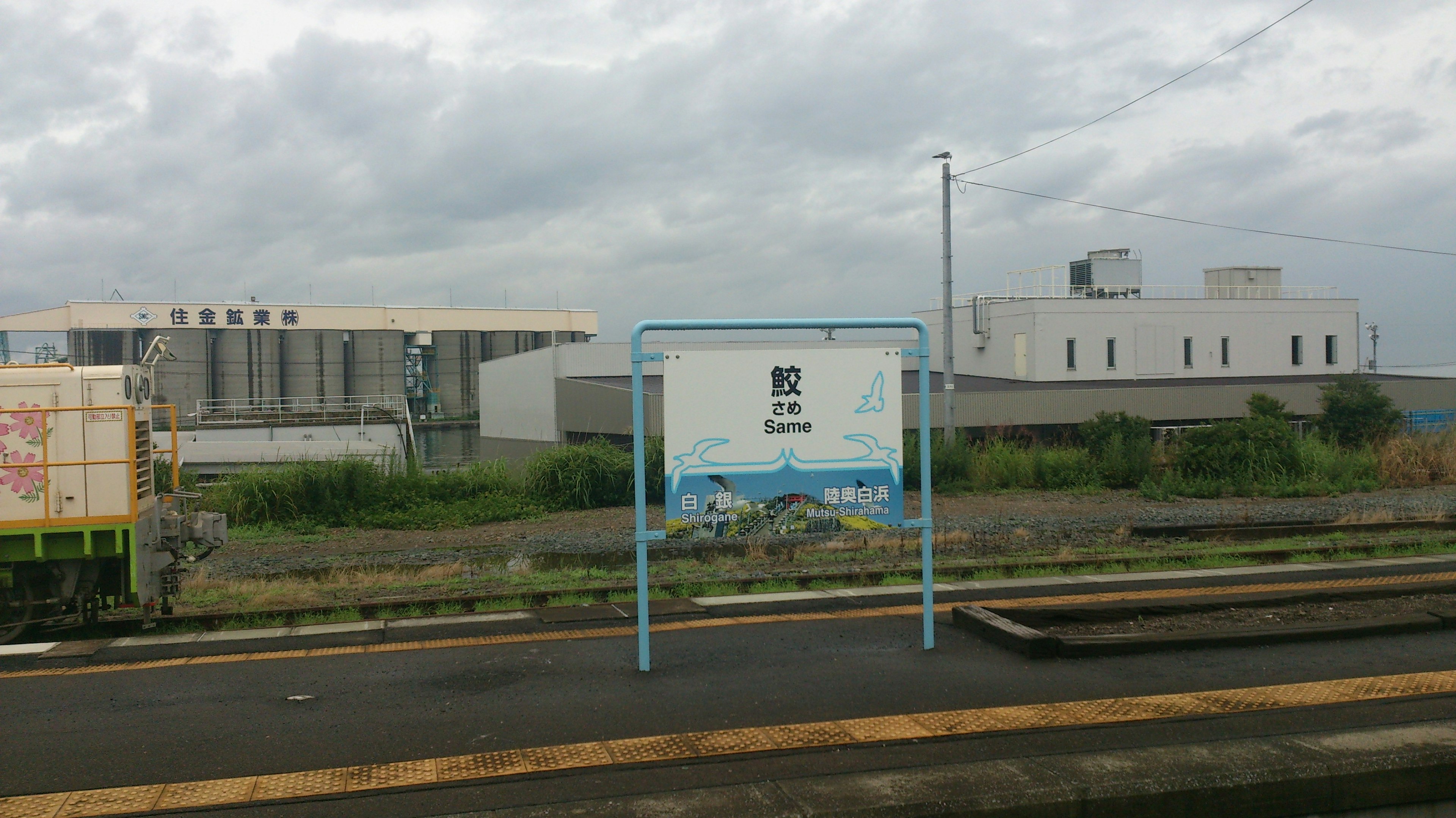 駅の看板と周辺の建物がある風景