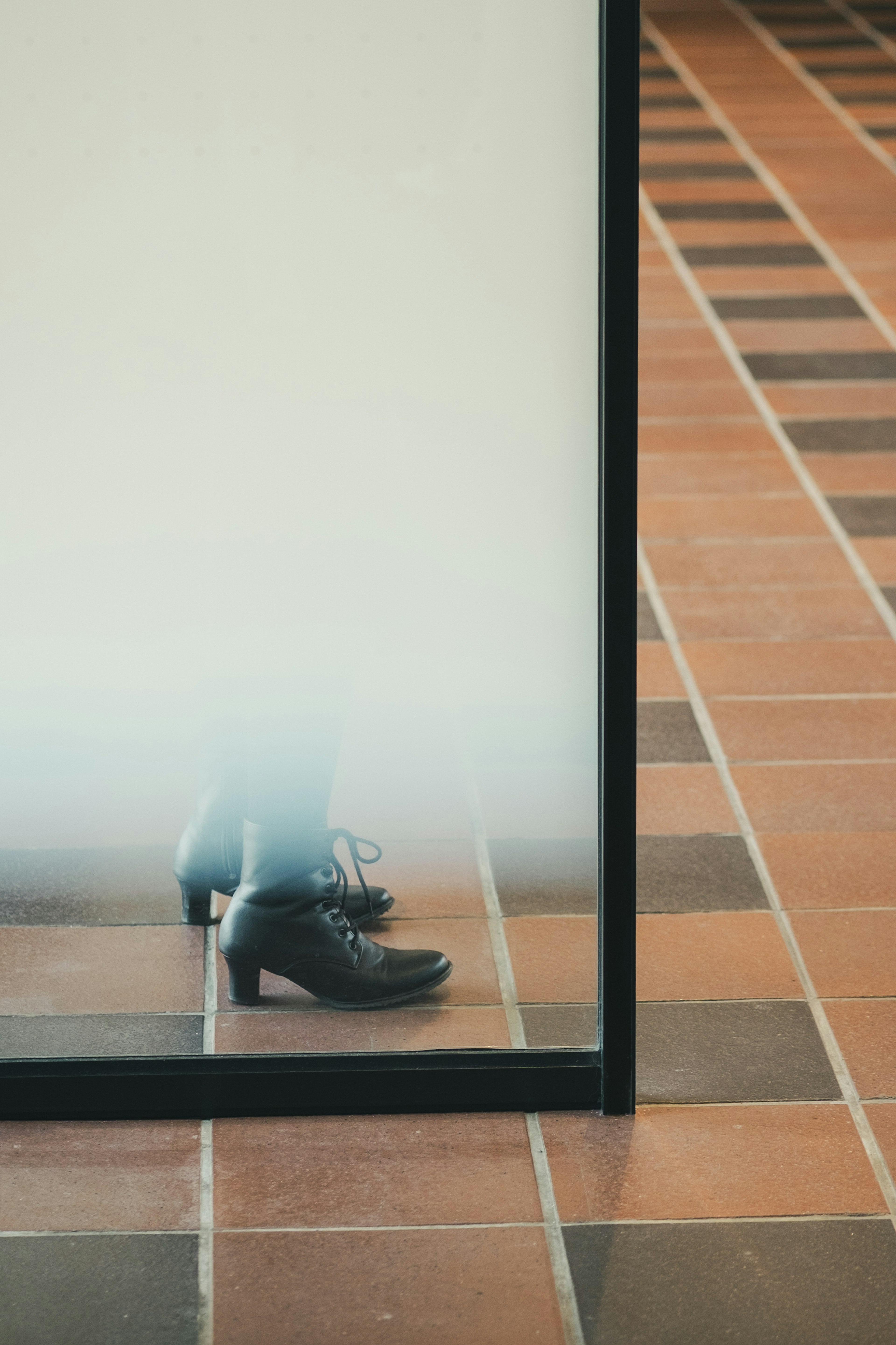 Reflection of shoes in a mirror with tiled floor