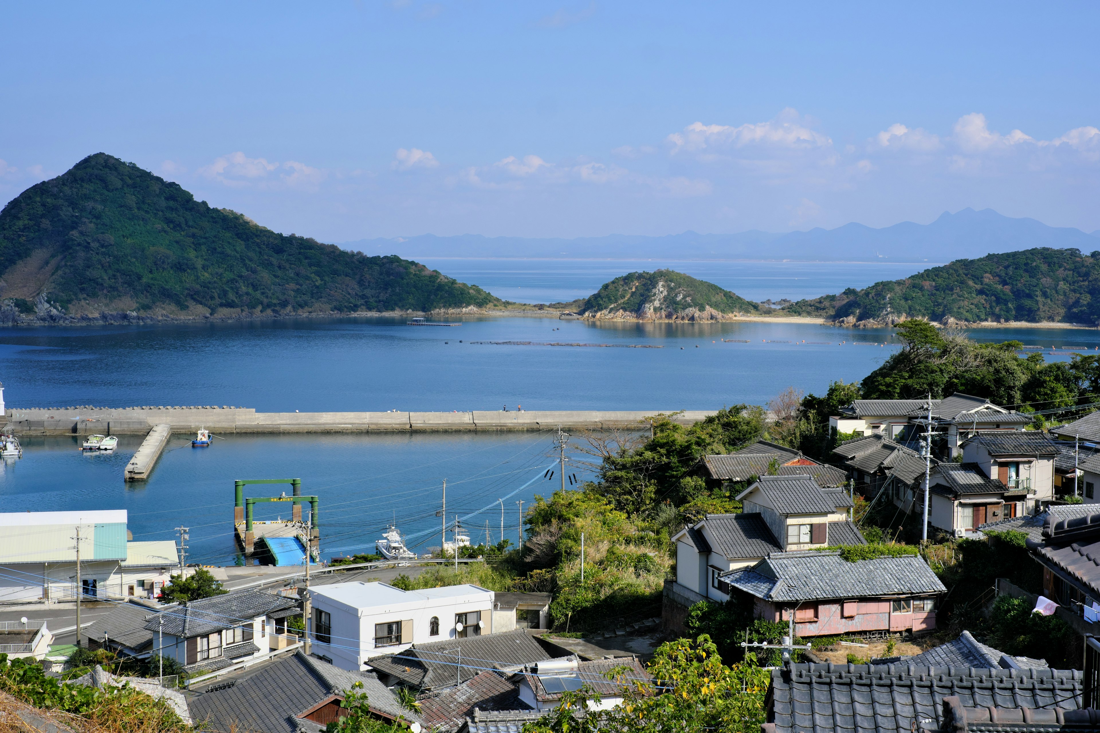 Scenic view of a coastal village surrounded by mountains and water