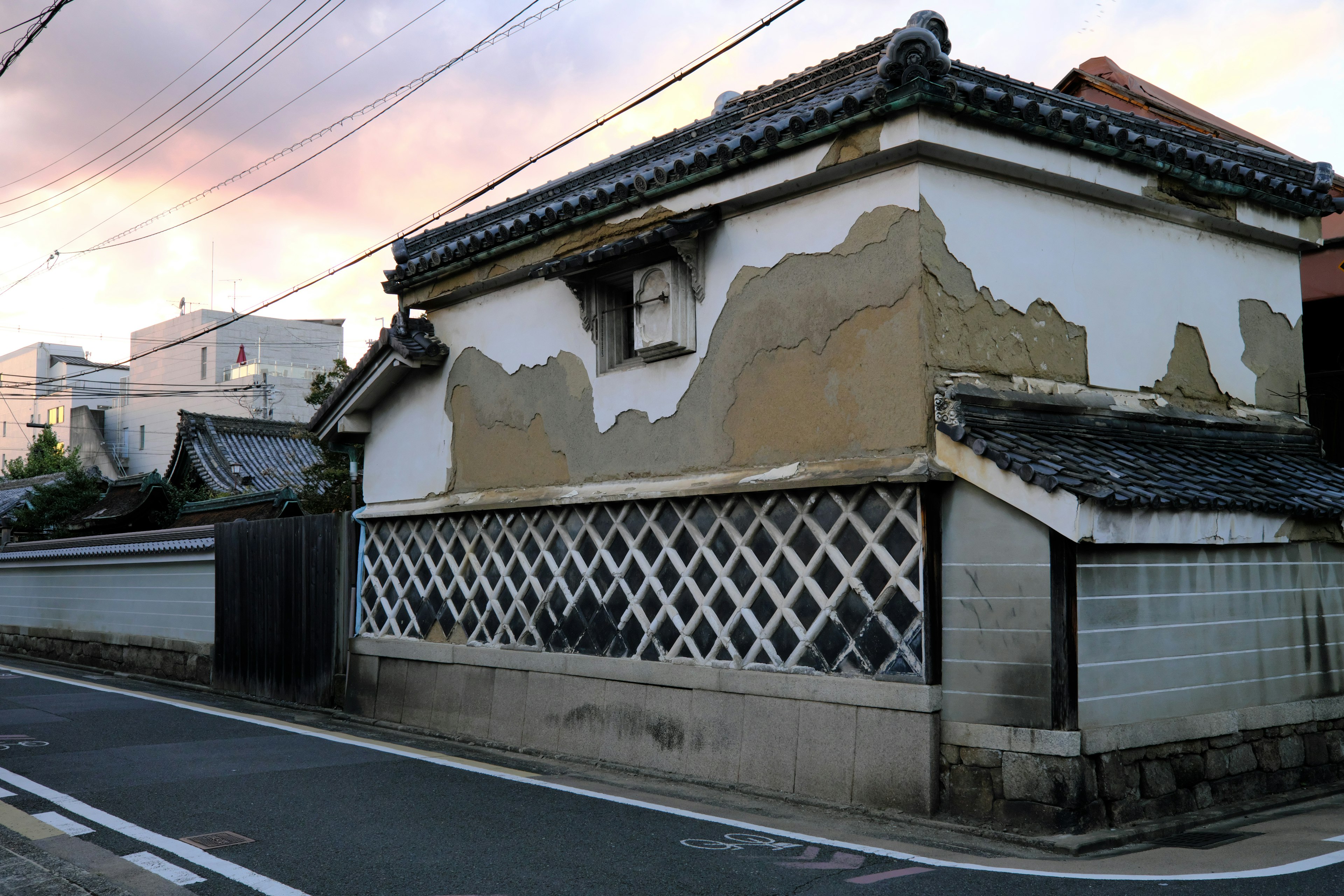 Extérieur d'une vieille maison japonaise avec de la peinture écaillée et des fenêtres en treillis