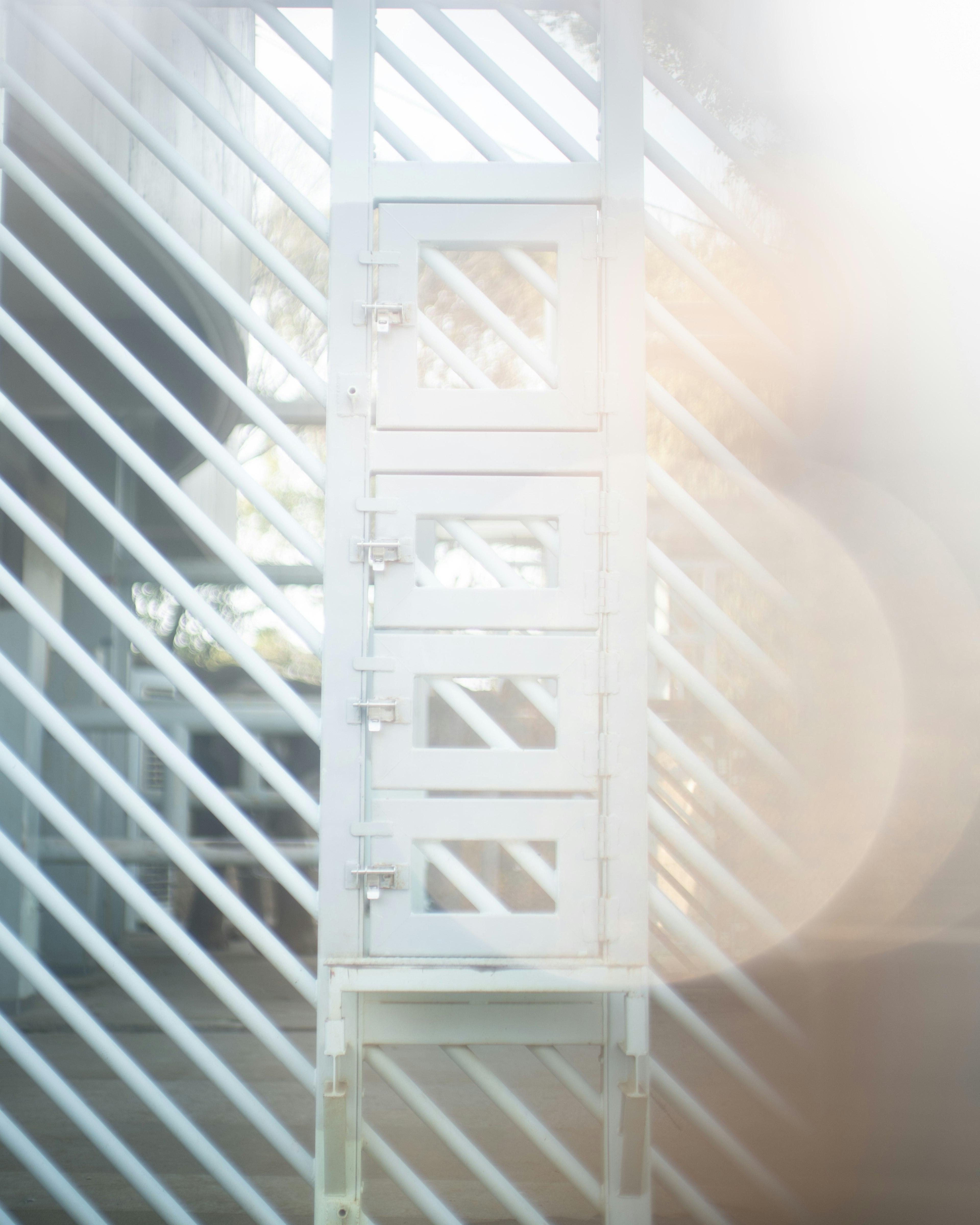 White storage boxes lined up against a backdrop of diagonal light