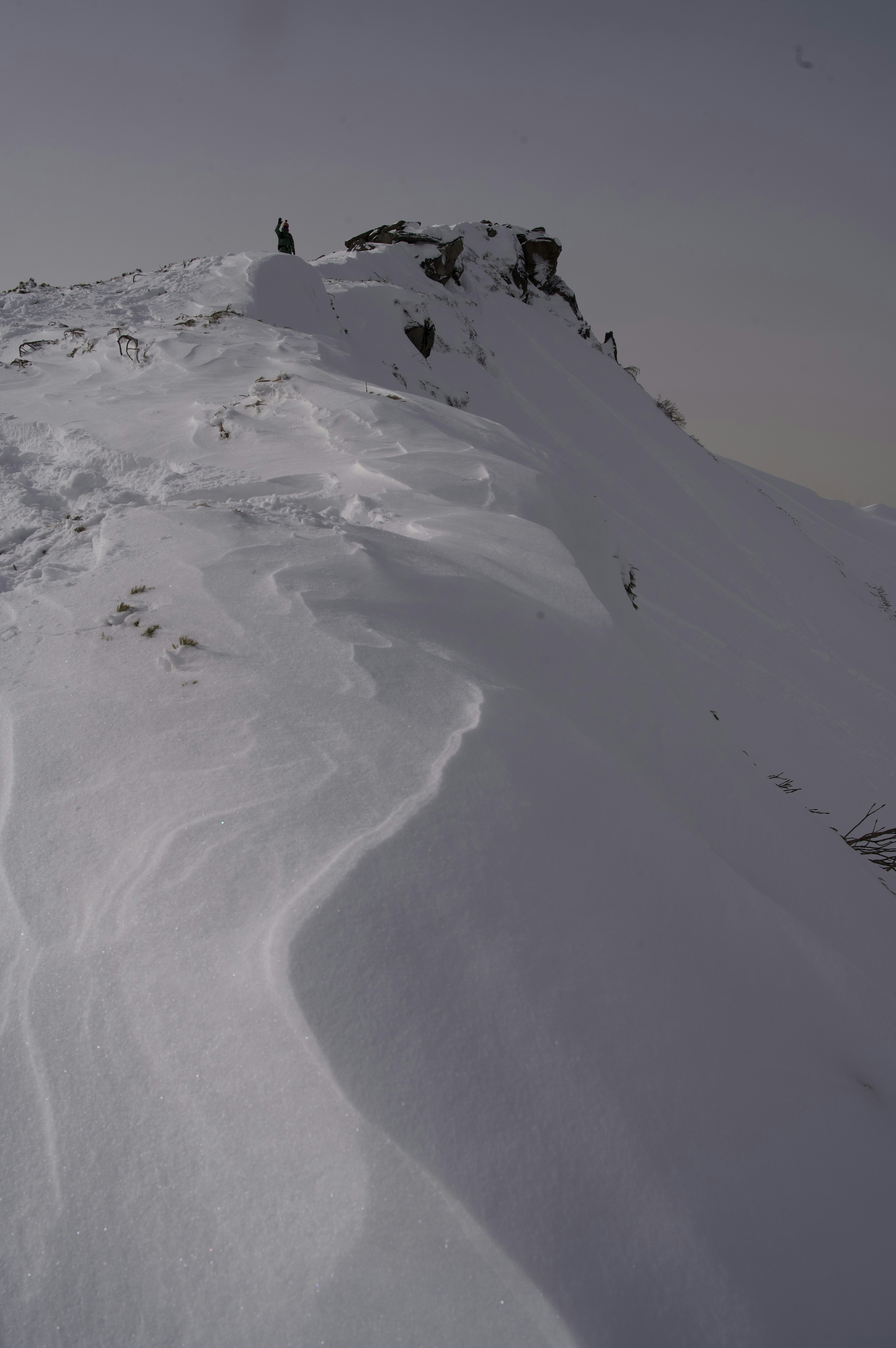 Cima de montaña cubierta de nieve con pendientes suaves