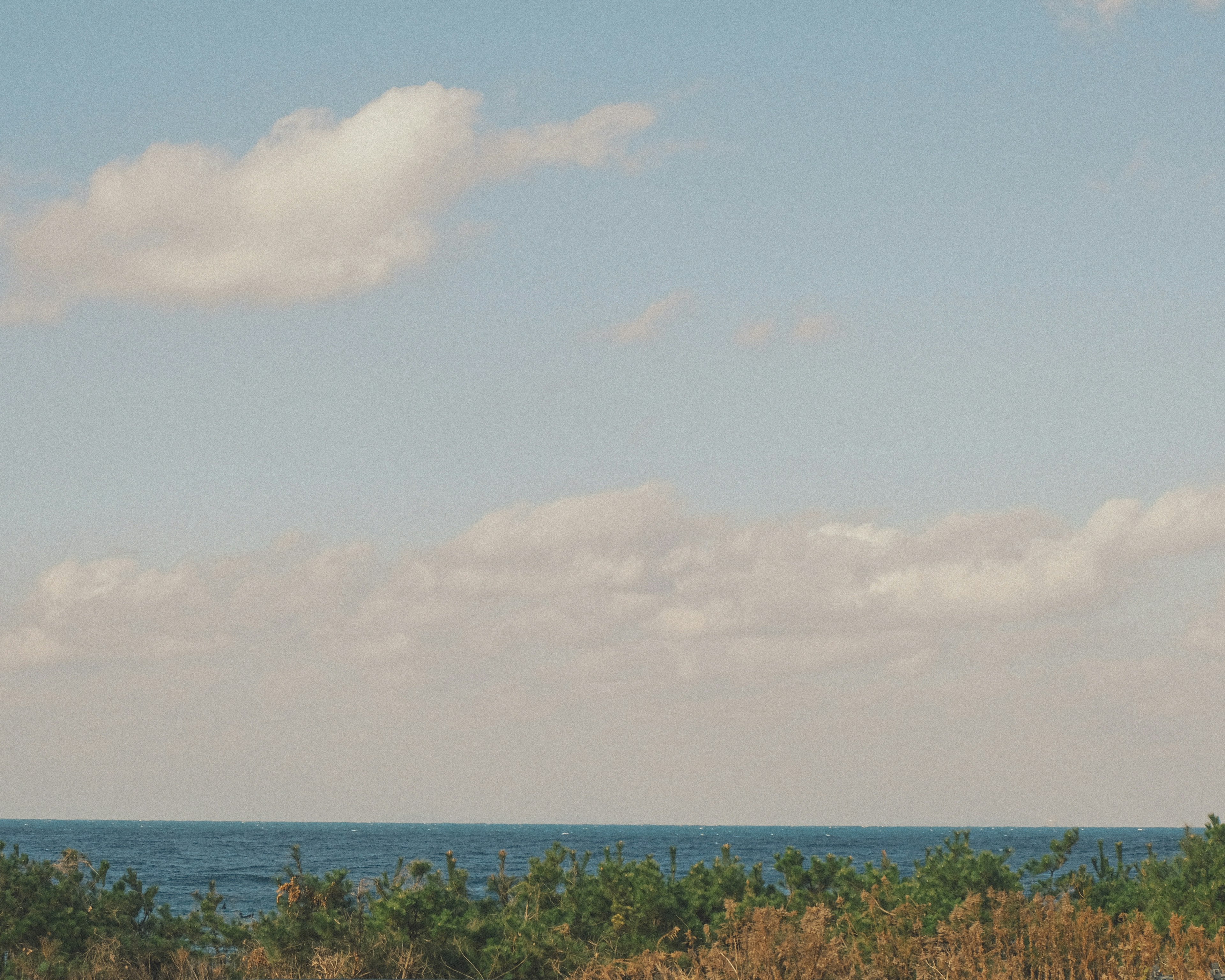 Landschaft mit blauem Meer und Wolken am Himmel