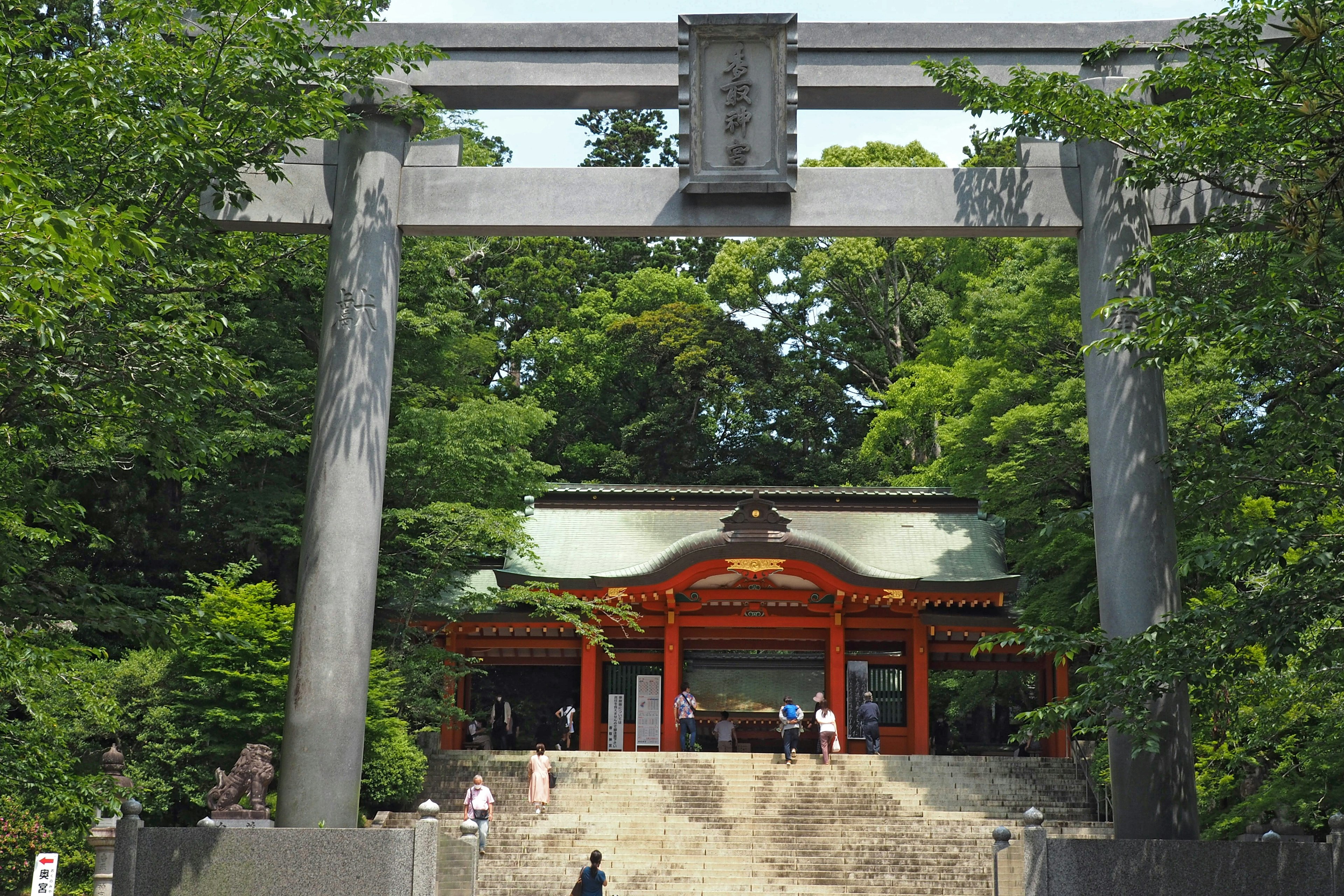 Puerta torii y santuario rojo rodeados de vegetación