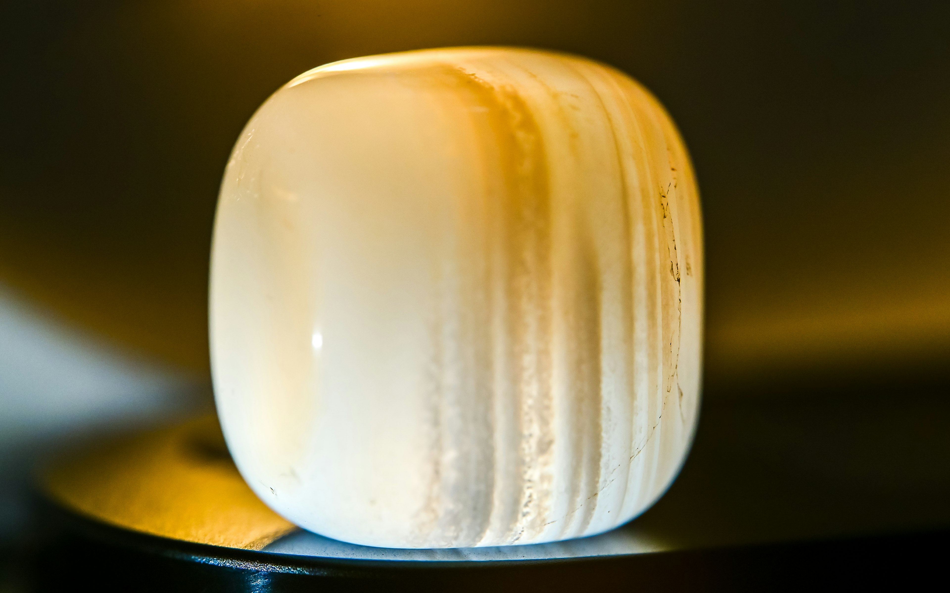 A translucent white stone with rounded edges illuminated by soft light