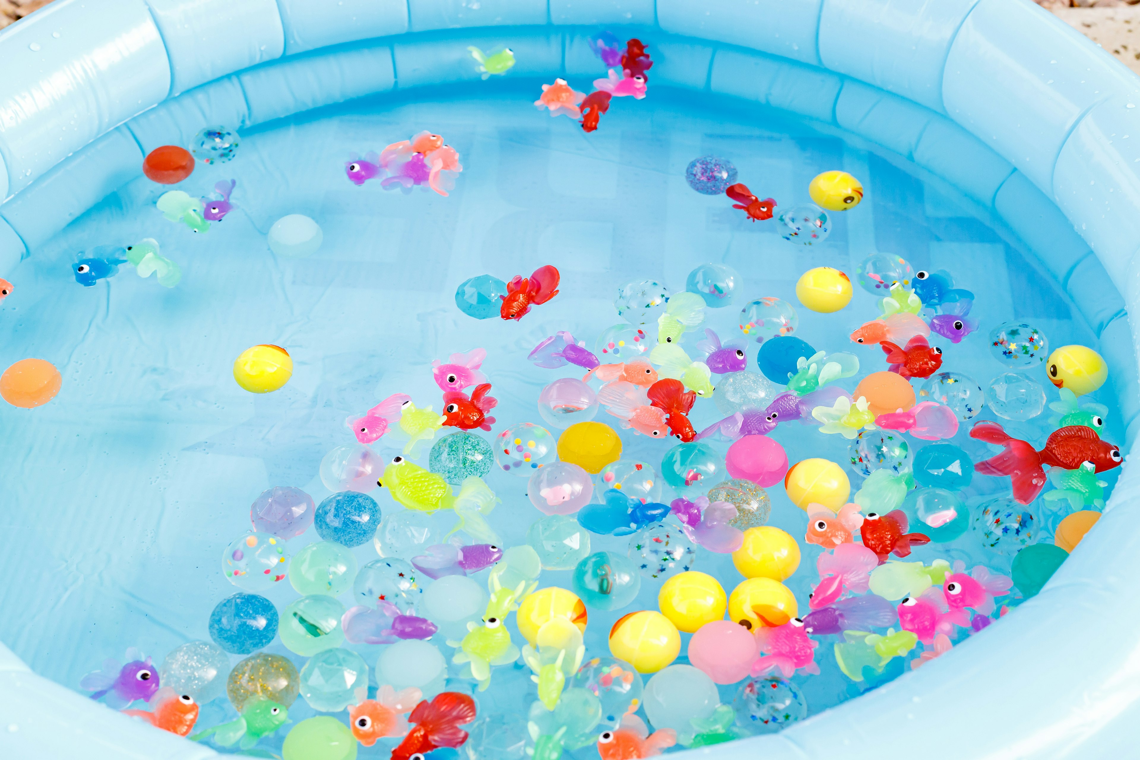 Giocattoli di plastica colorati che galleggiano in una piscina blu