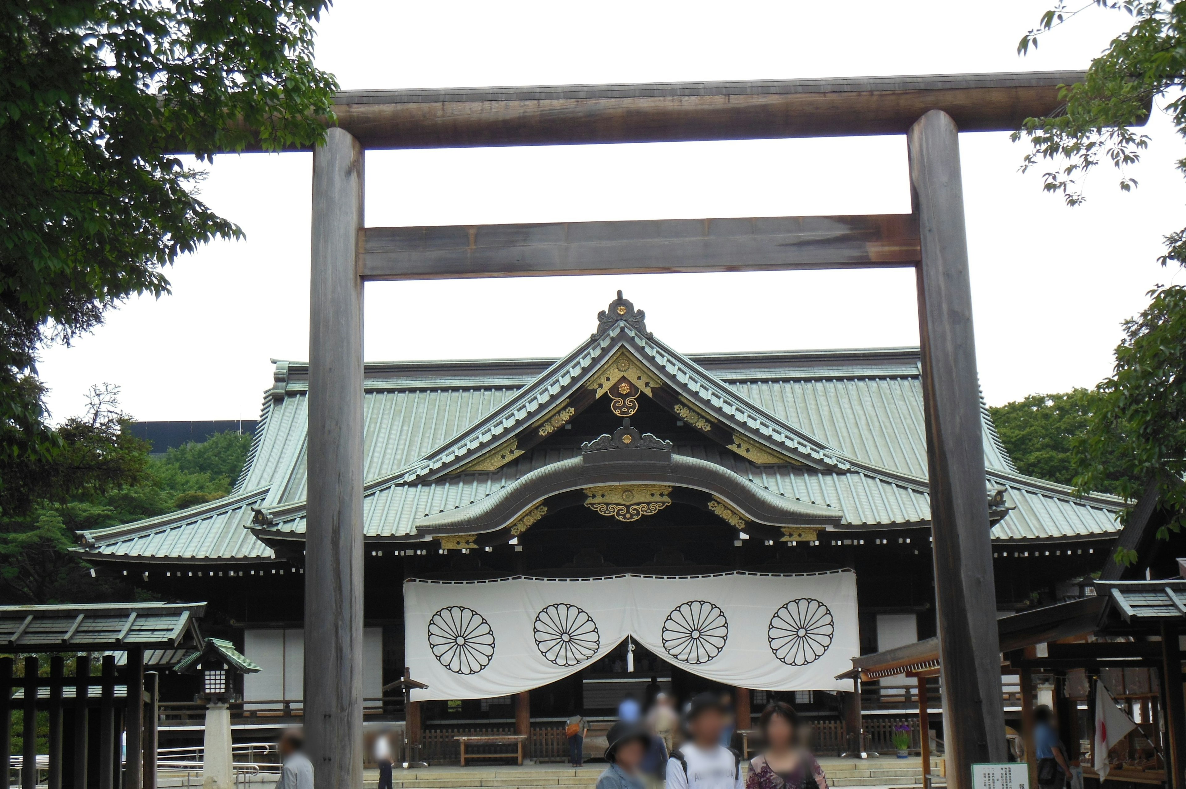 Pintu torii dengan bangunan kuil tradisional di latar belakang