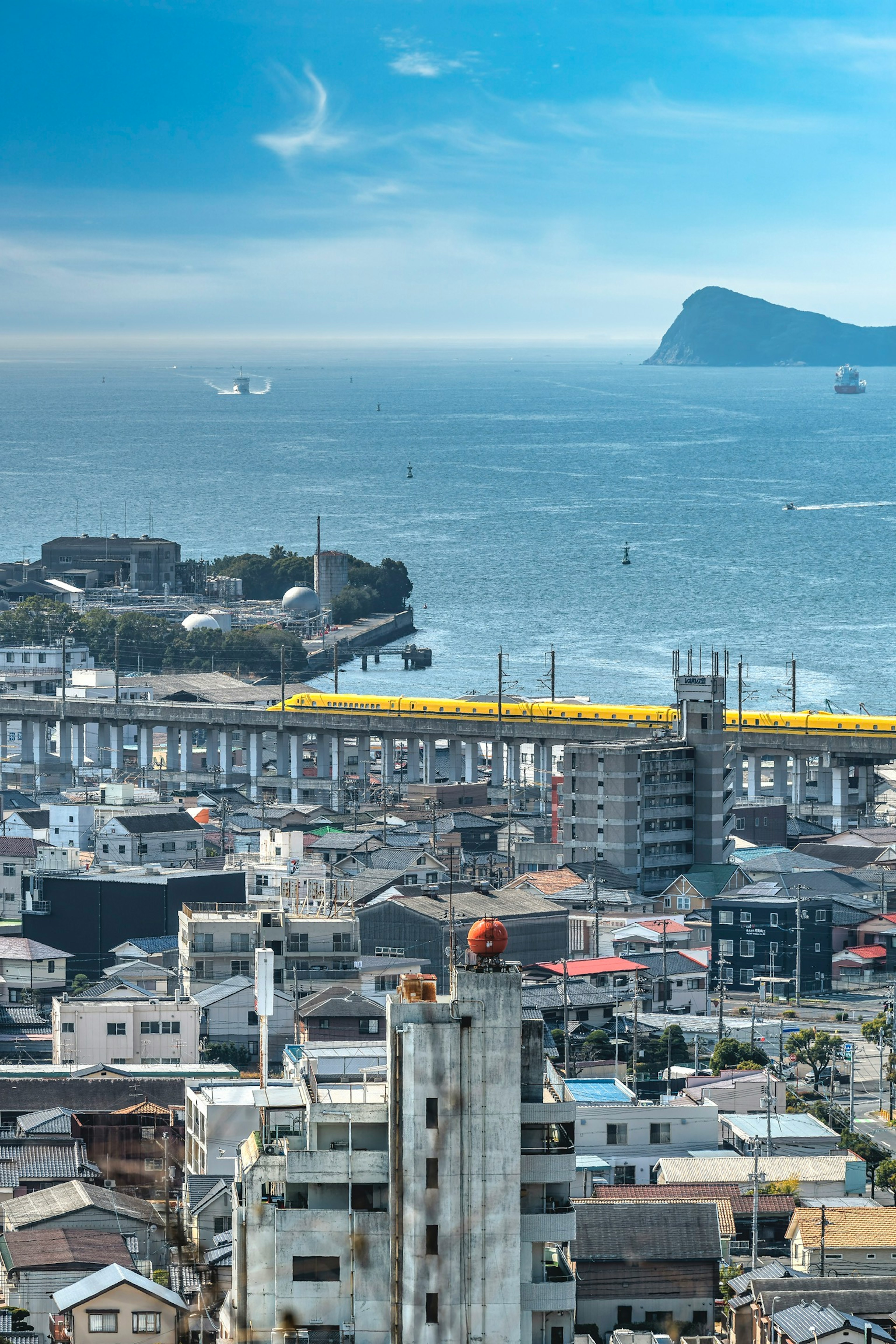 City skyline with ocean view featuring high-rise buildings and a bridge