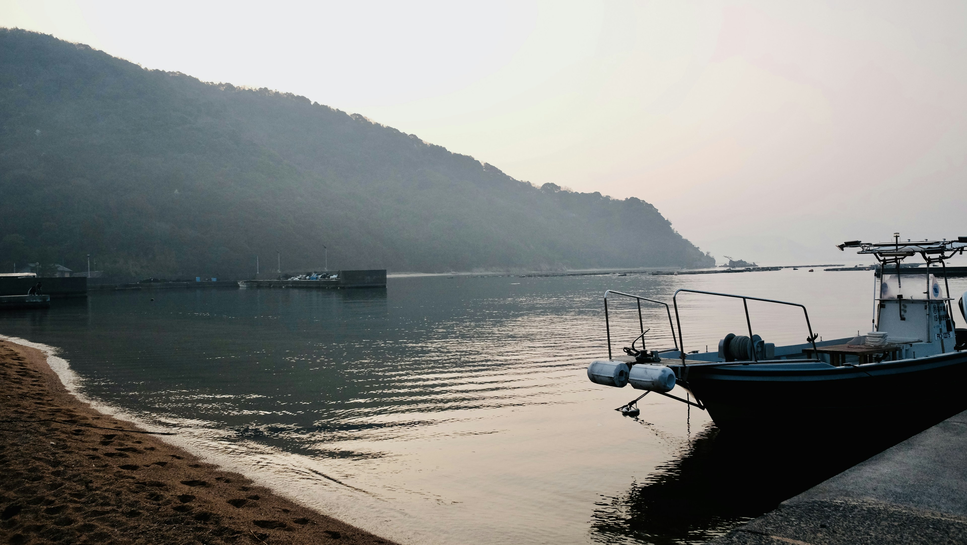 Garis pantai yang tenang dengan perahu kecil di air