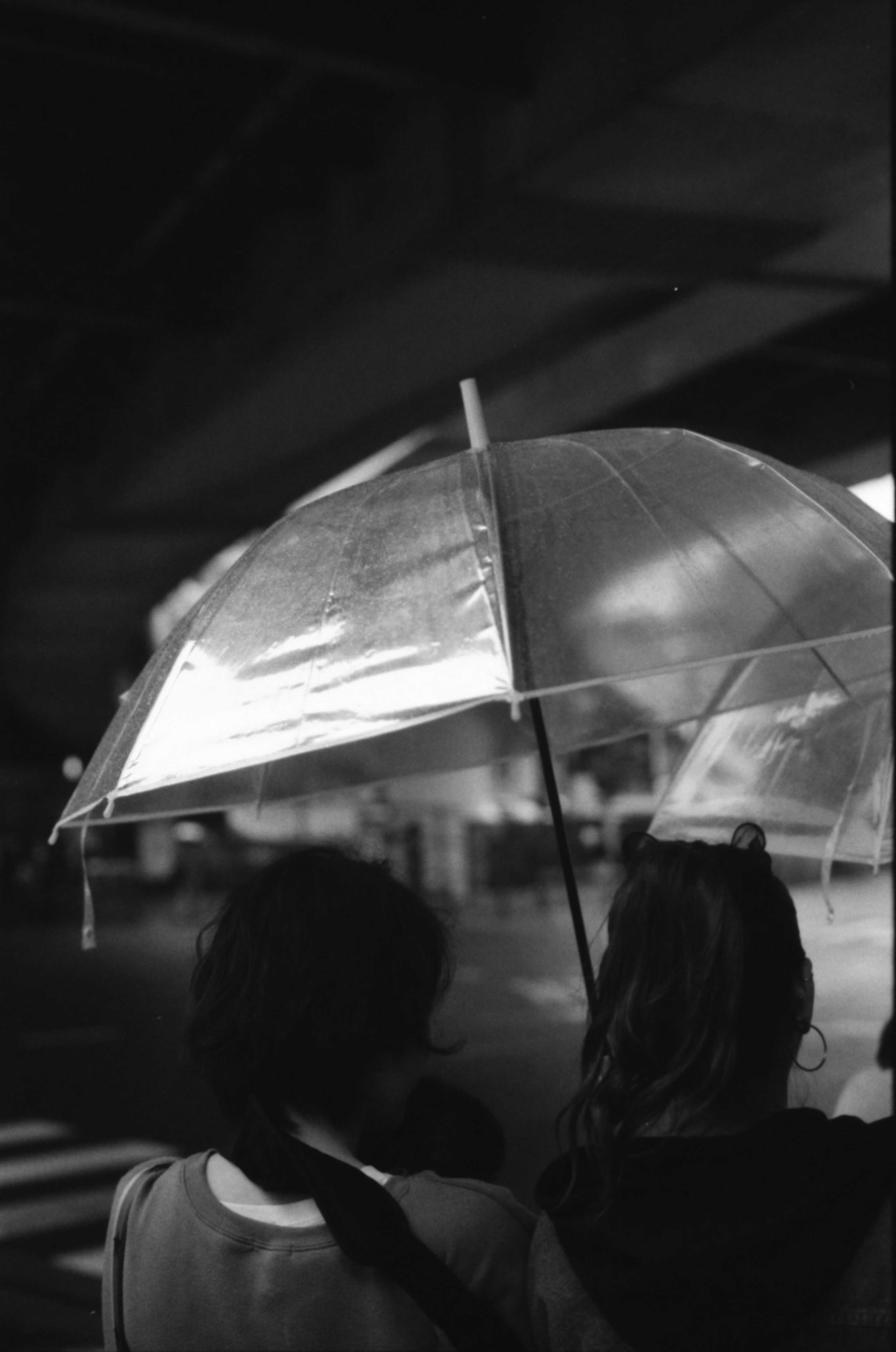 Silhouettes de deux personnes sous un parapluie transparent