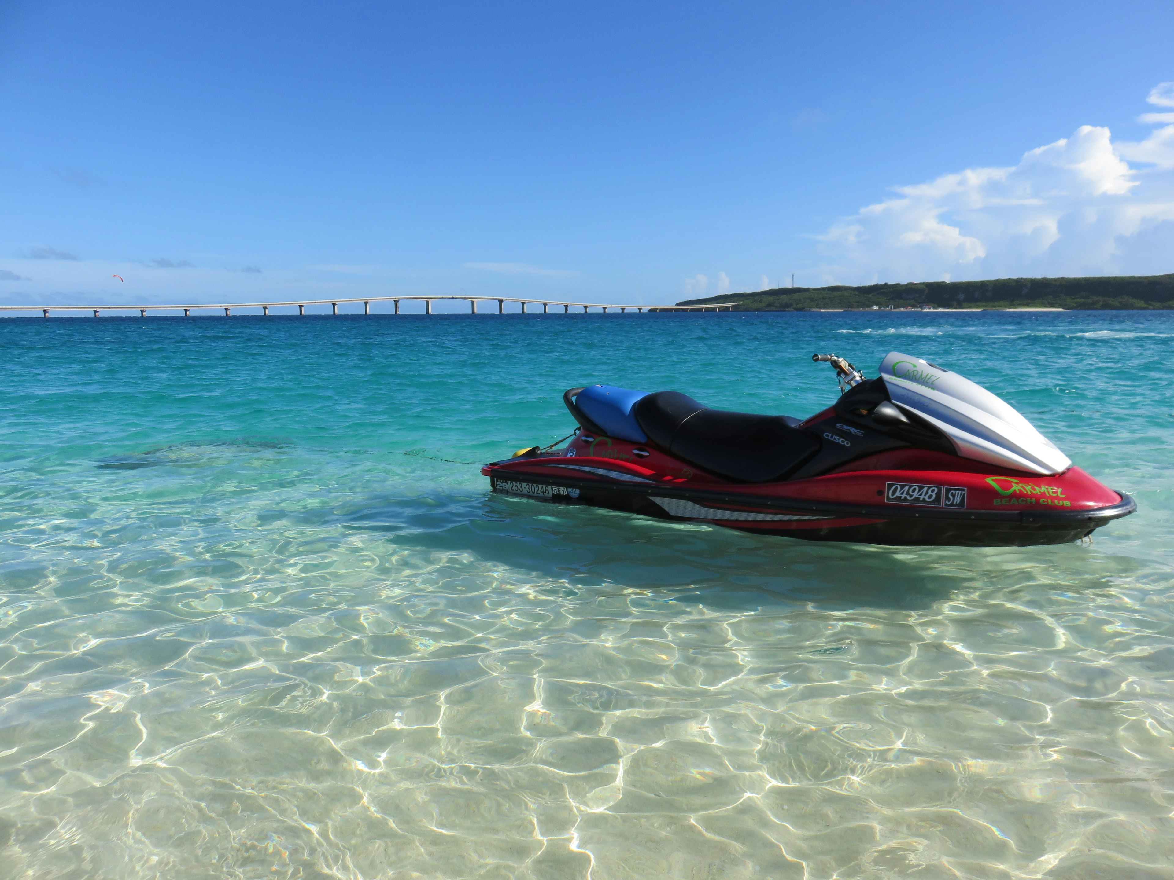 Moto d'acqua rossa che galleggia in acqua blu chiara