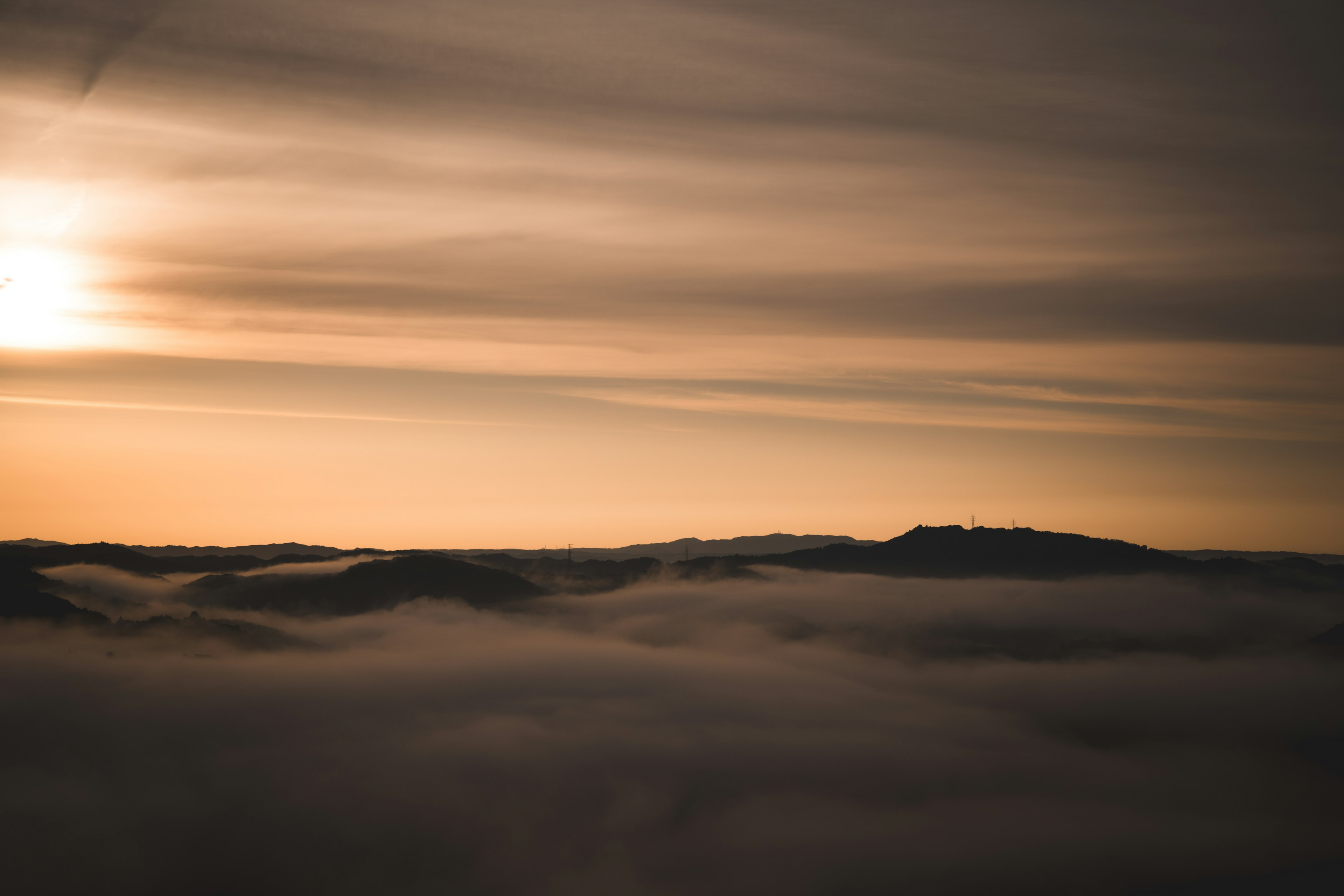 Mountains shrouded in mist with a serene sunset sky