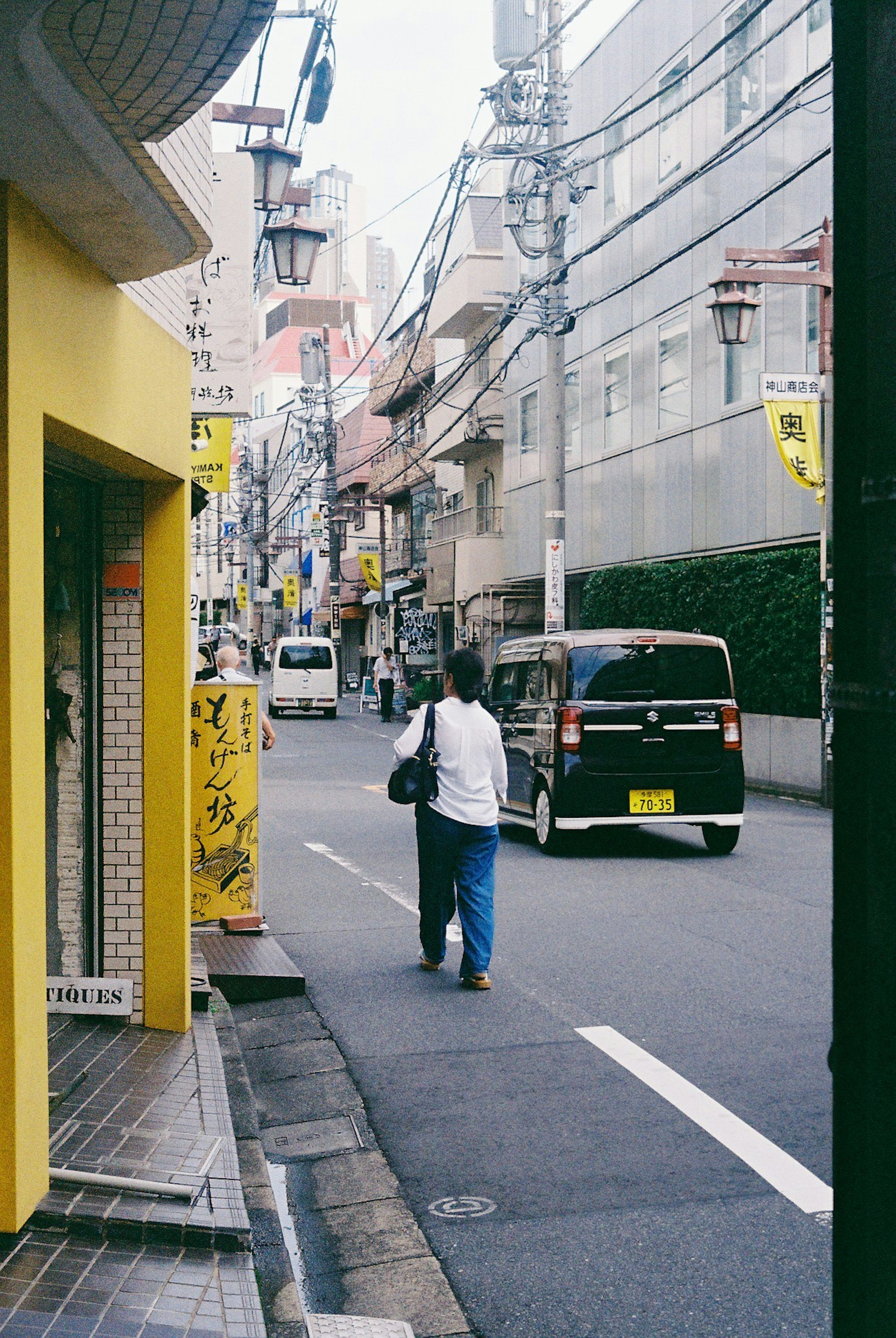 Escena de calle con un edificio amarillo y una persona caminando