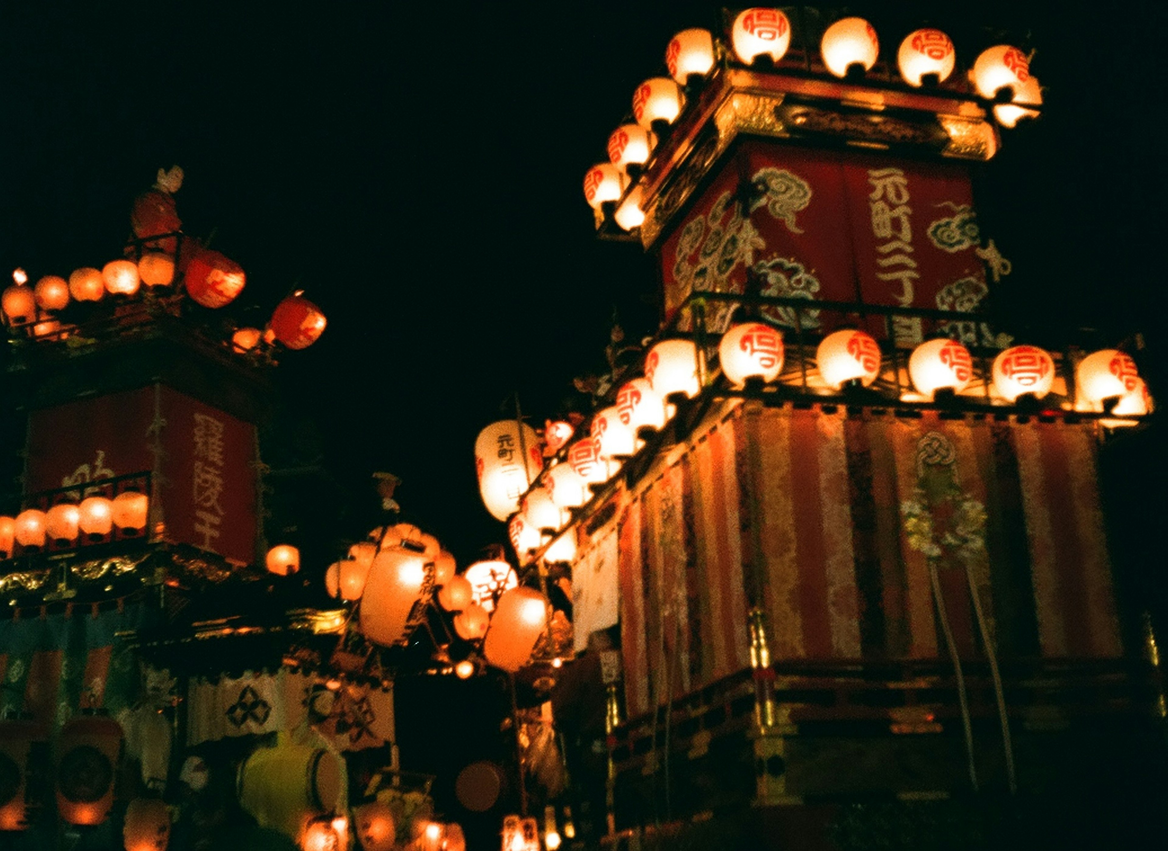 Chariots de festival ornés de lanternes et de décorations la nuit