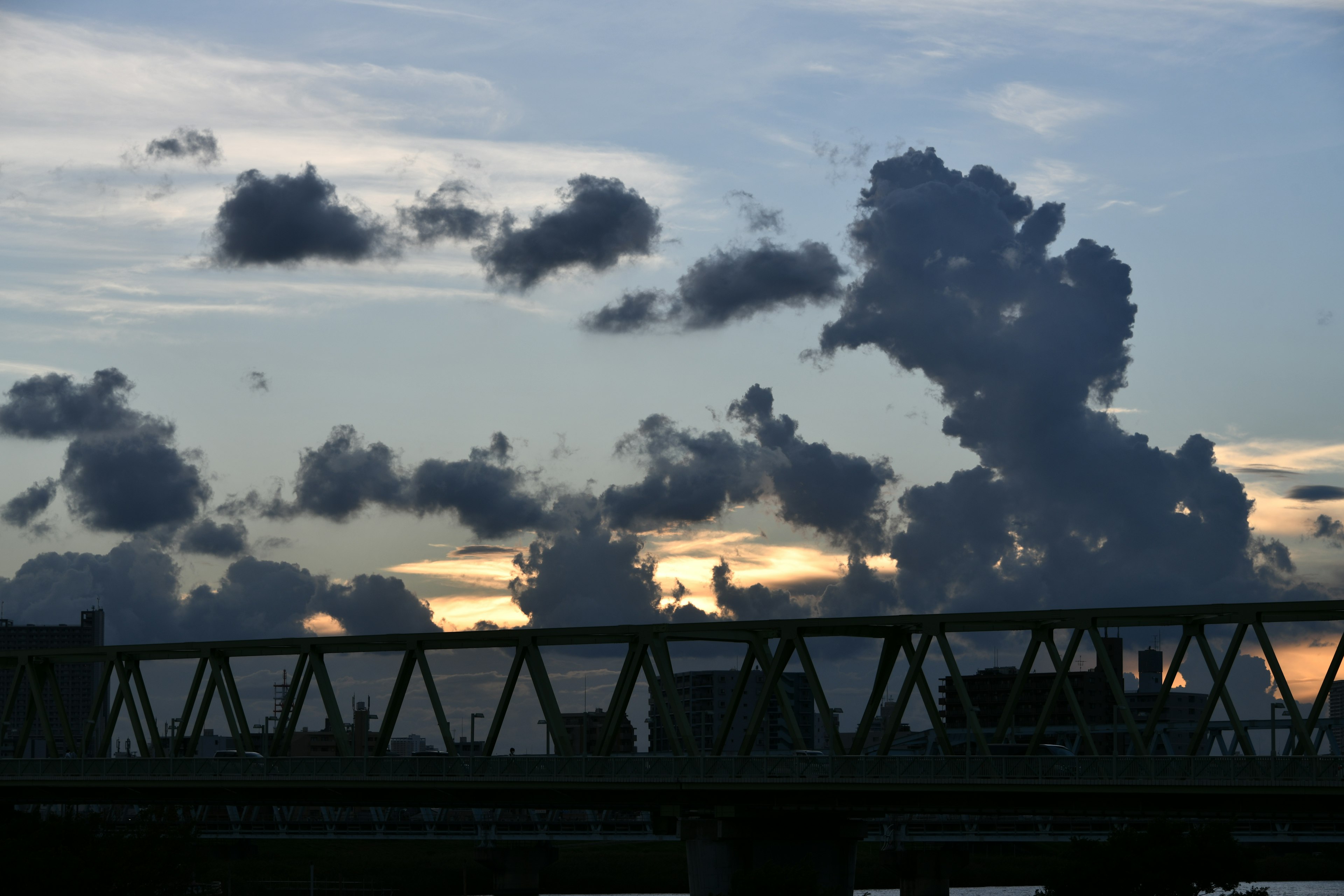 夕焼けの雲と橋のシルエットがある風景