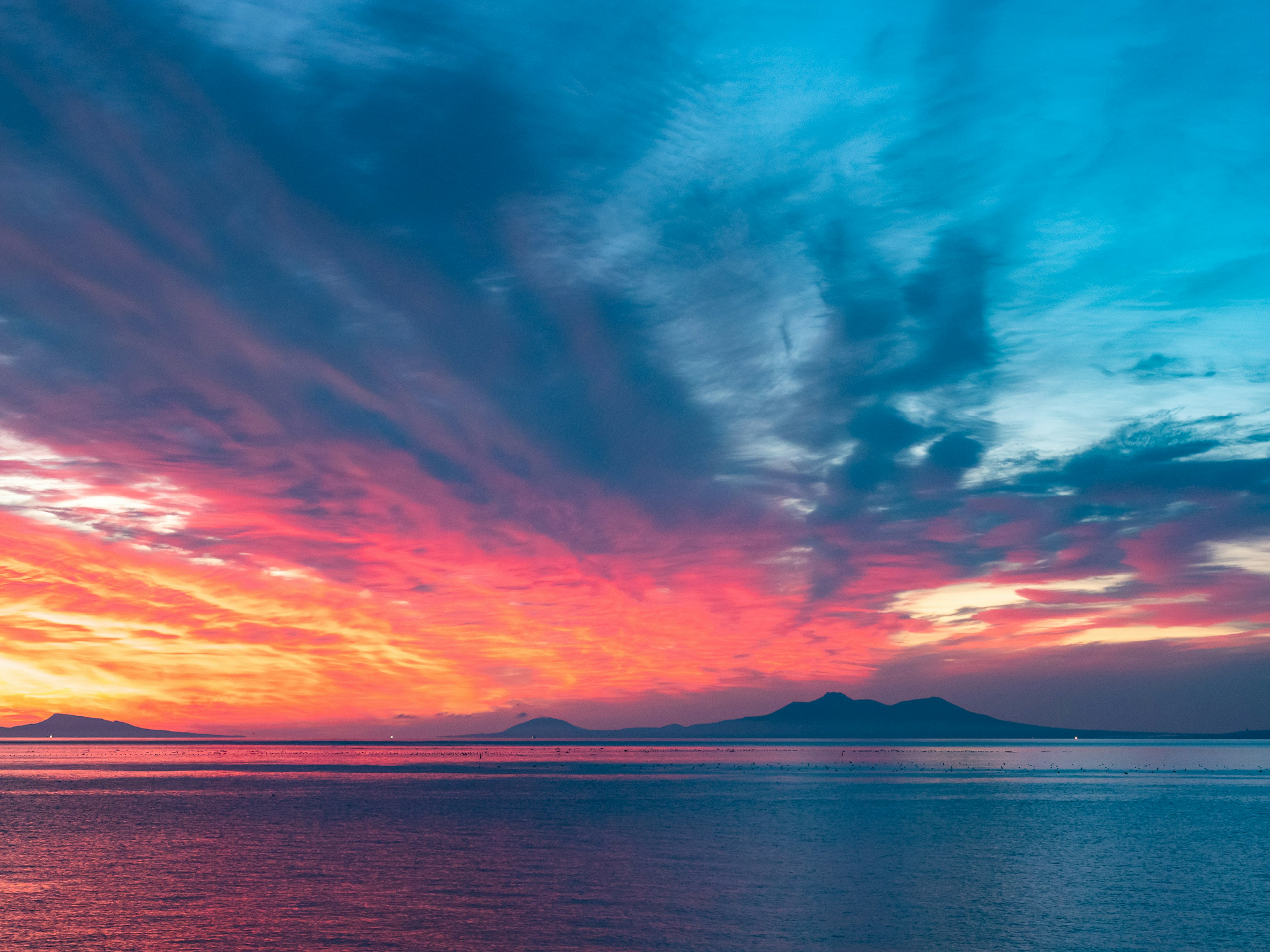 Schöner Sonnenuntergang über dem Ozean mit lebhaften blauen und roten Farbtönen