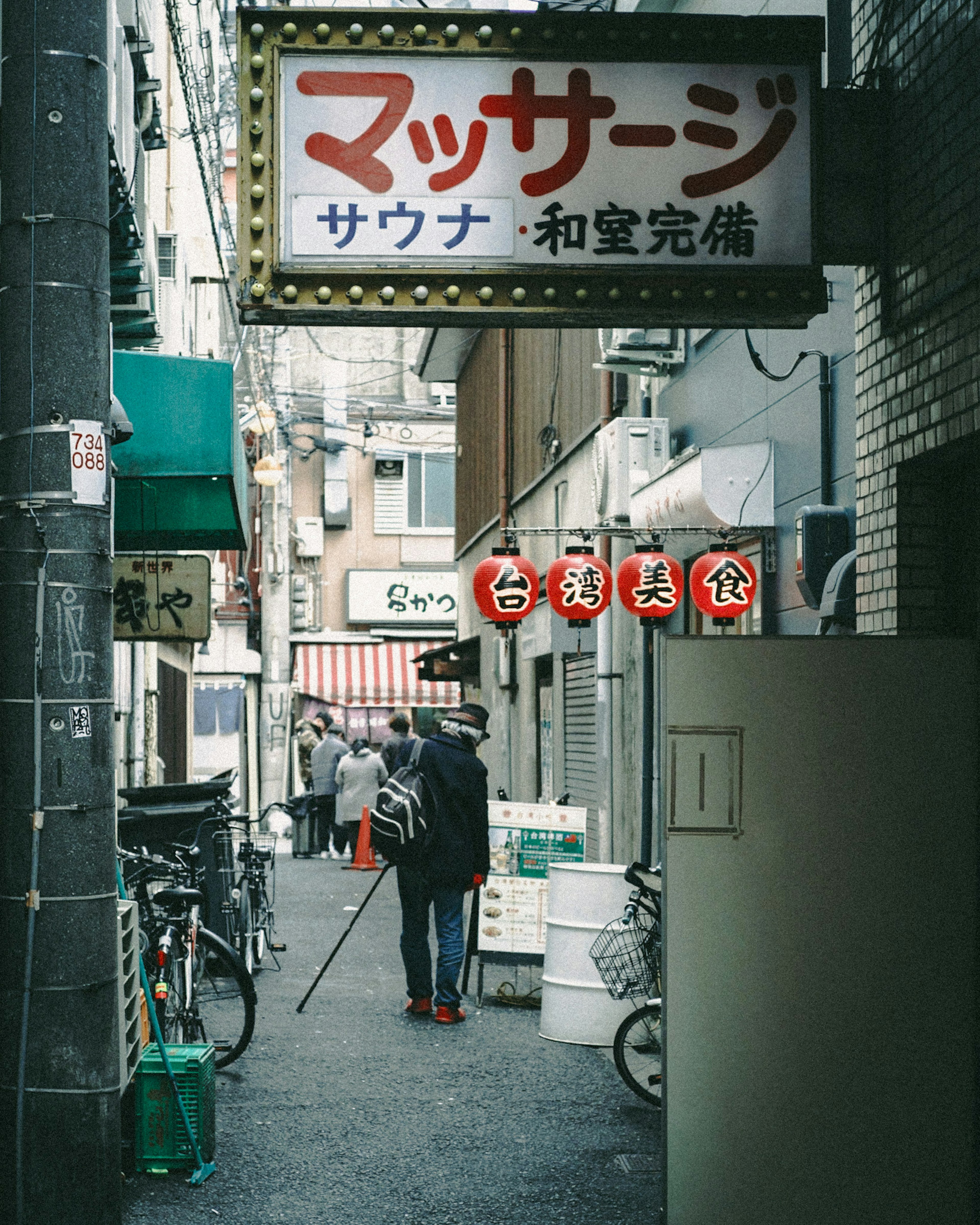 狭い通りにあるマッサージ店の看板が見える