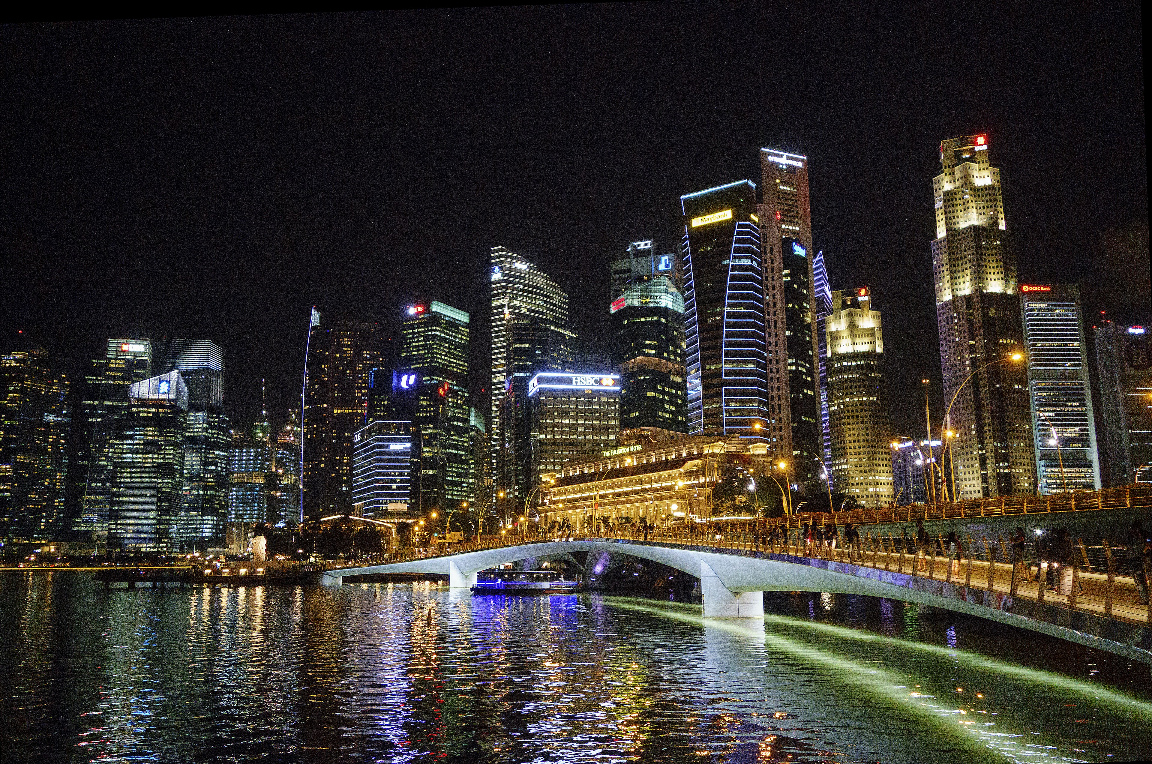 Skyline di Singapore di notte con grattacieli illuminati e un ponte