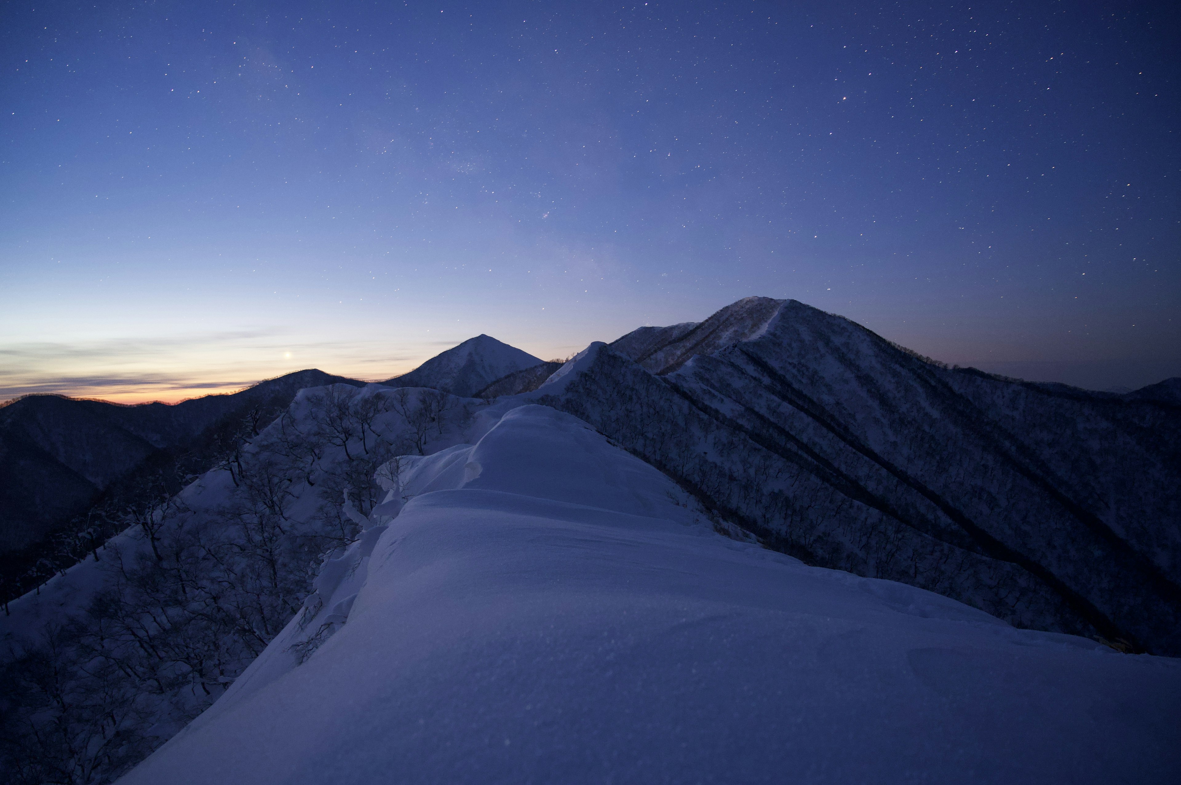 雪に覆われた山々と薄明かりの空