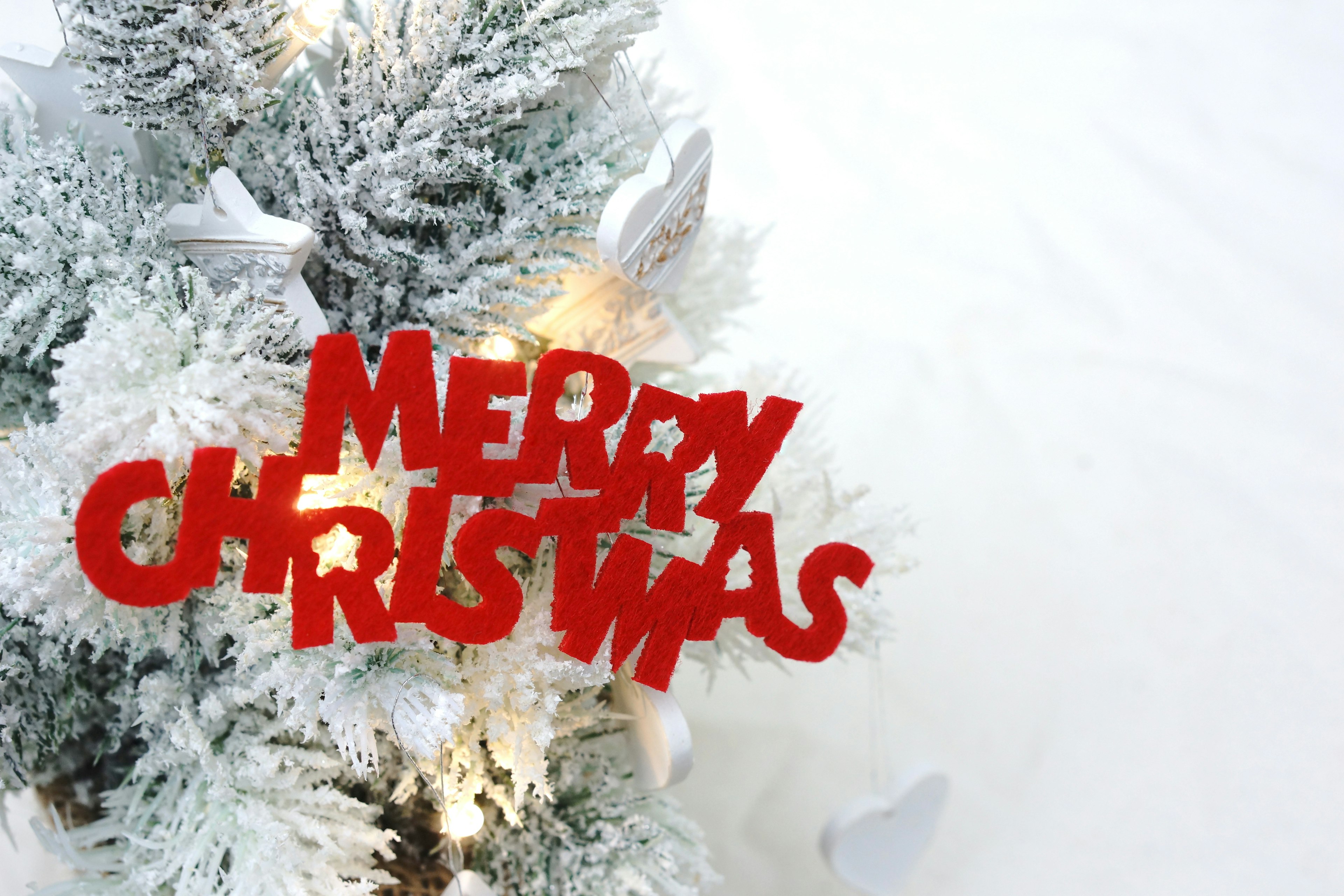 Snow-covered Christmas tree with red 'Merry Christmas' decoration