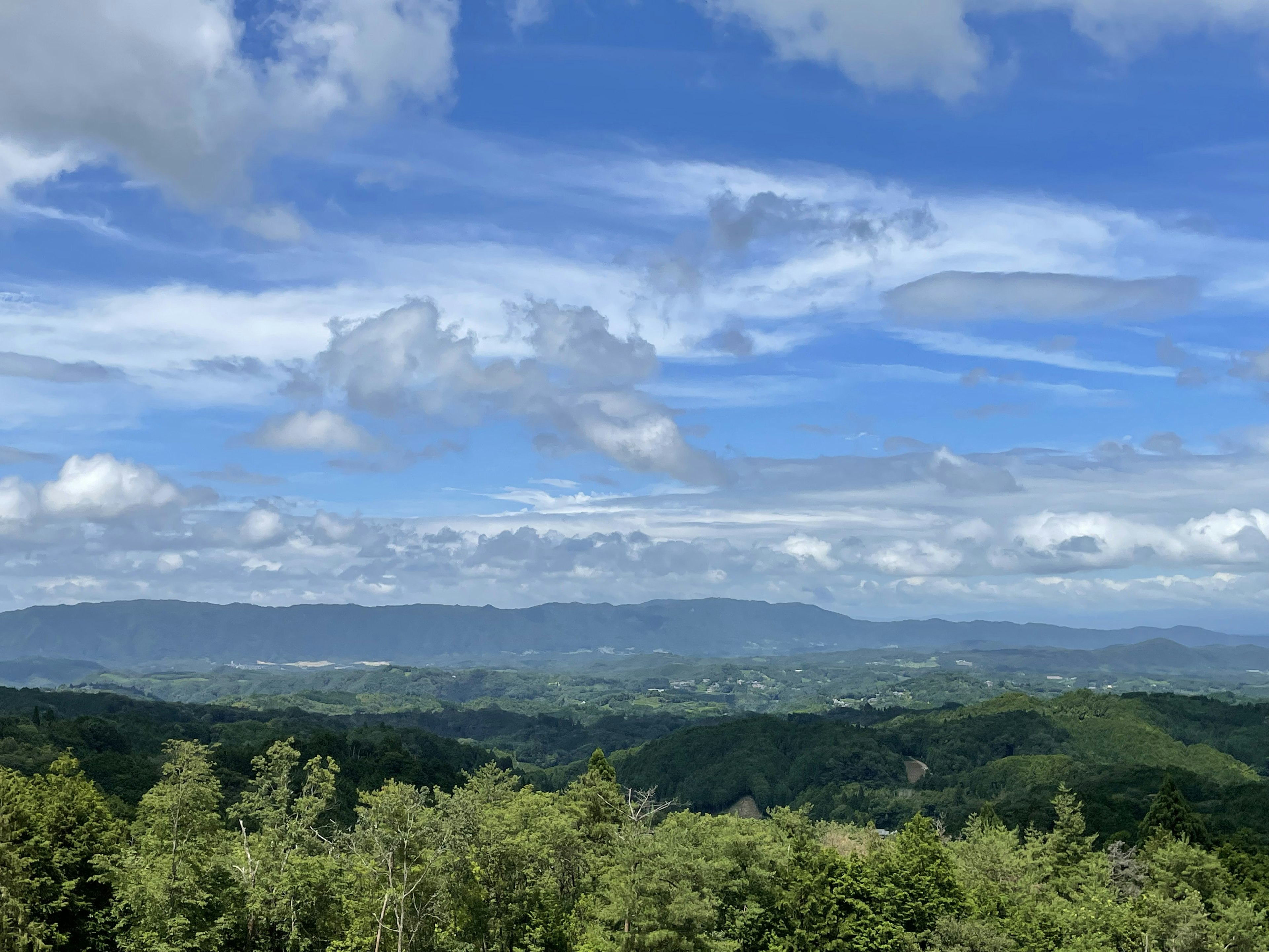 郁郁葱葱的绿色山脉在蓝天和云朵下的风景