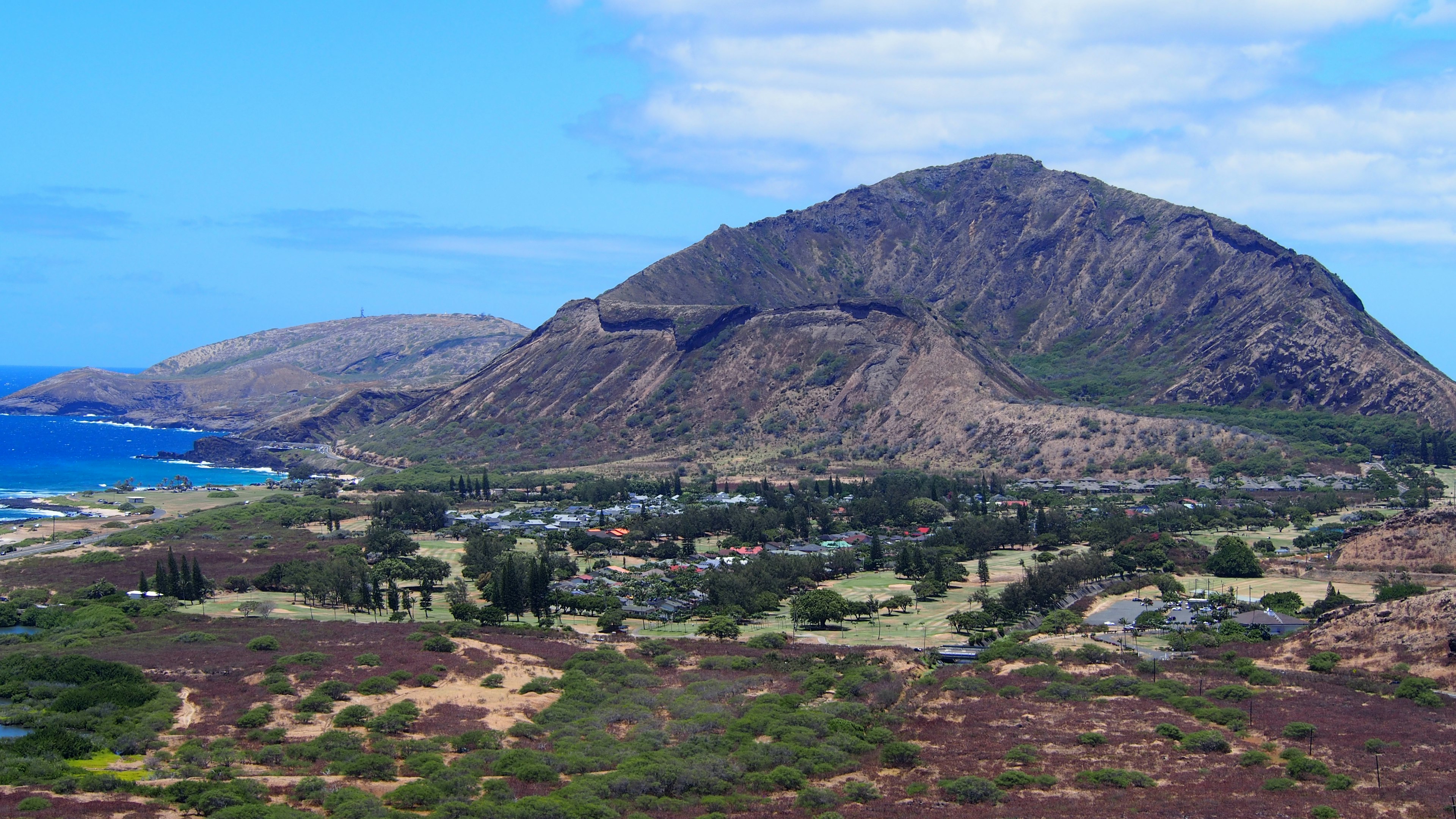 Scenic view of mountains and coastline with blue skies