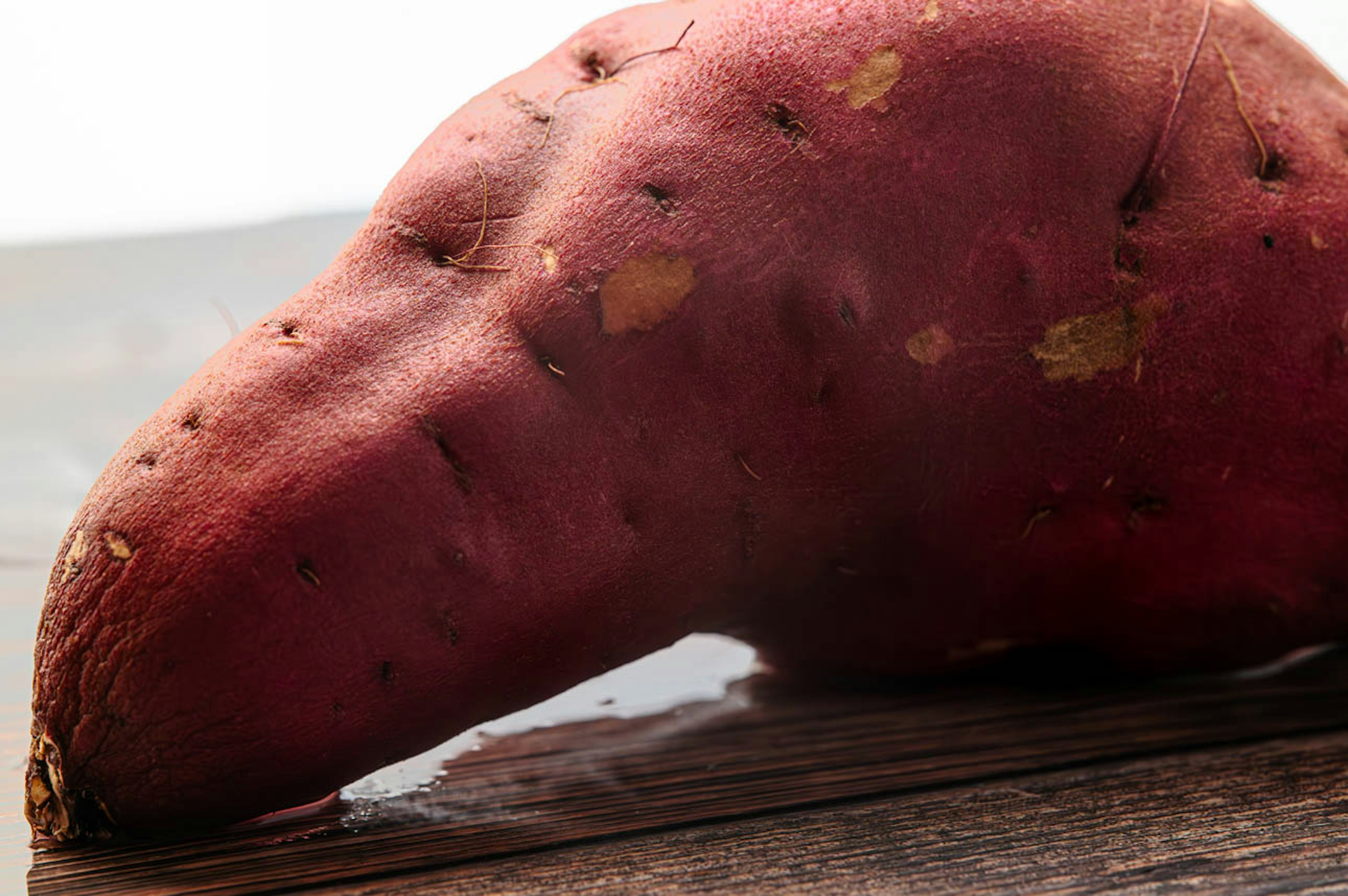 Red sweet potato placed on a wooden table