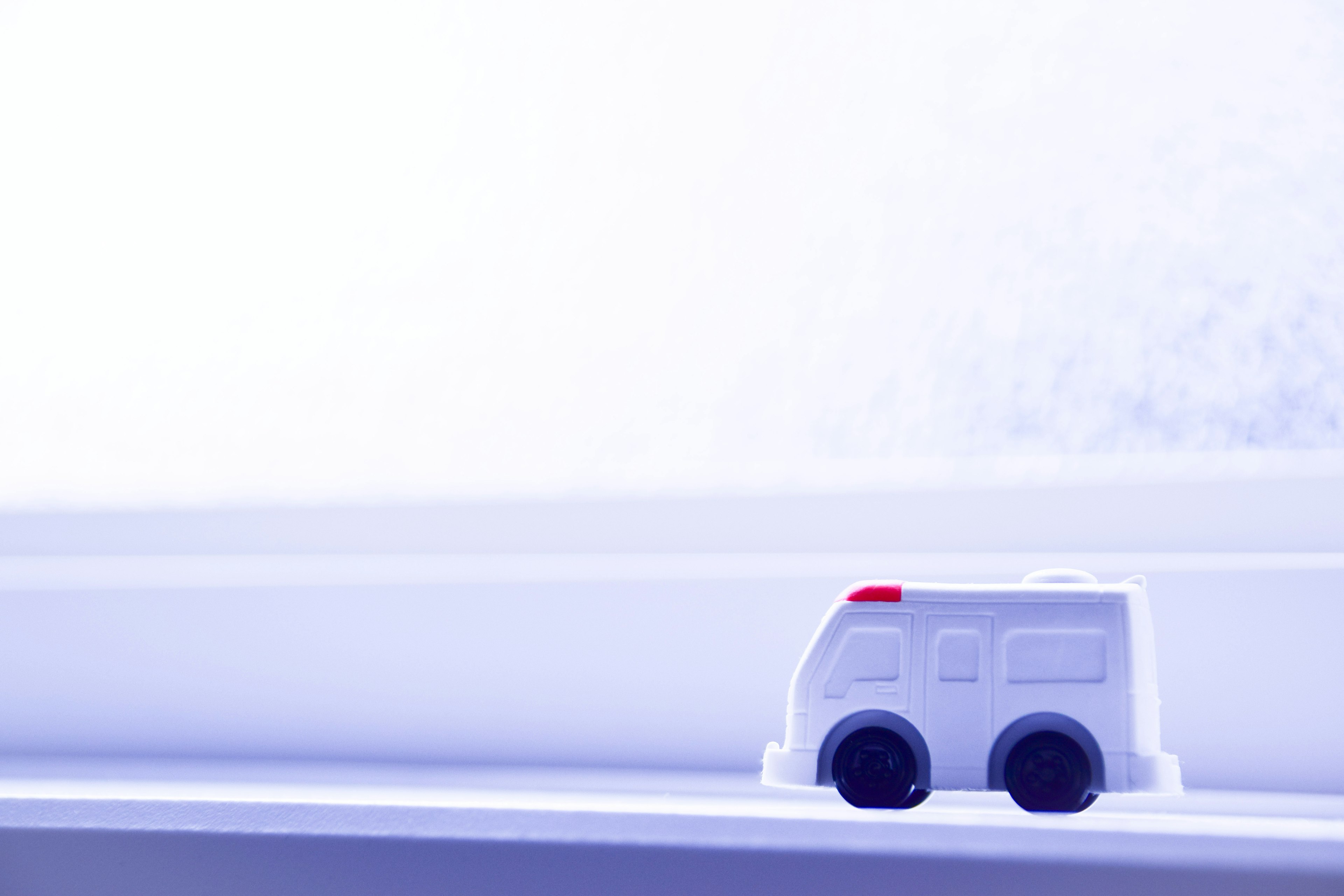 Small white toy ambulance against a light background