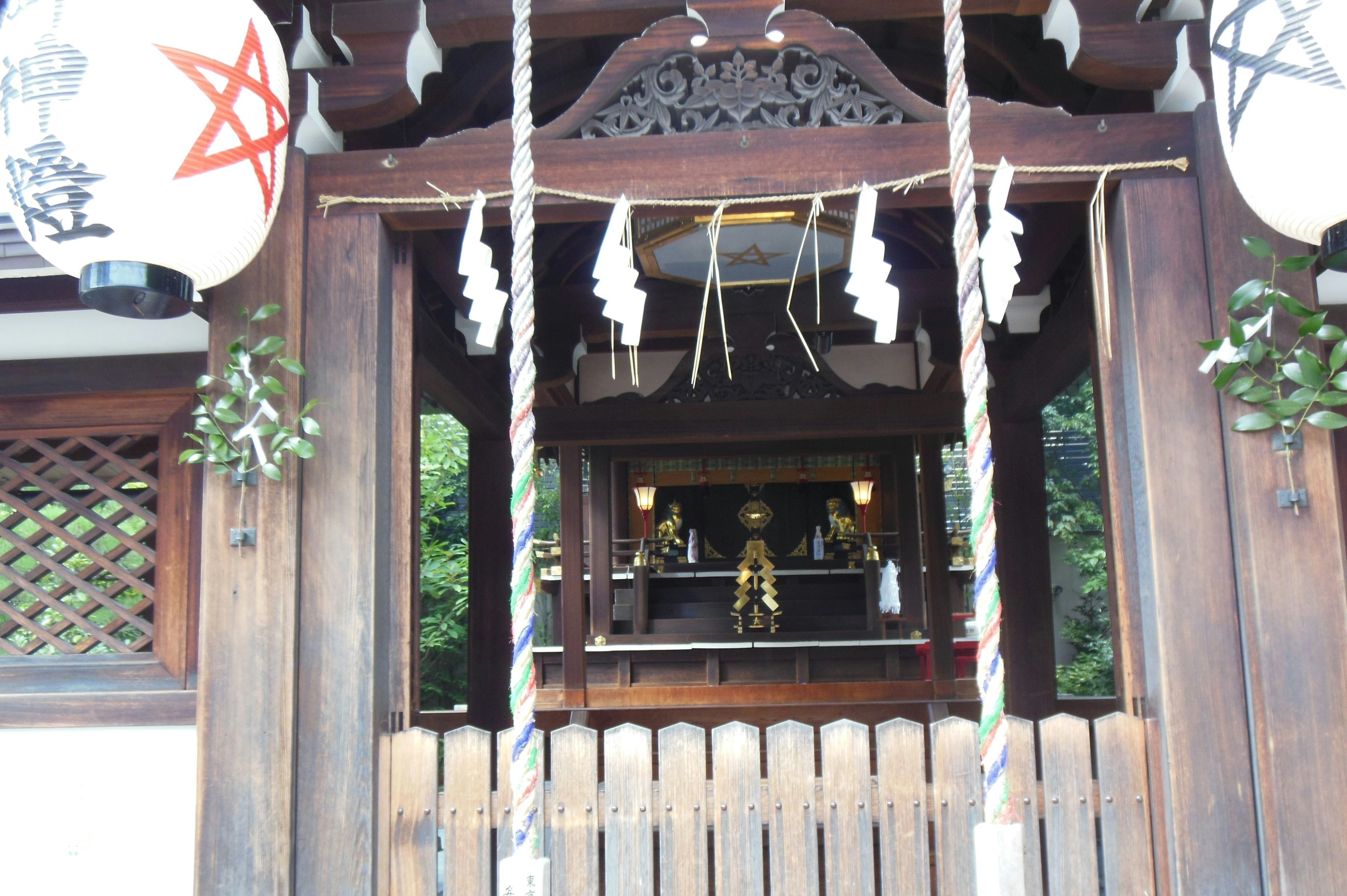 Entrance of a shrine featuring wooden doors and decorated lanterns