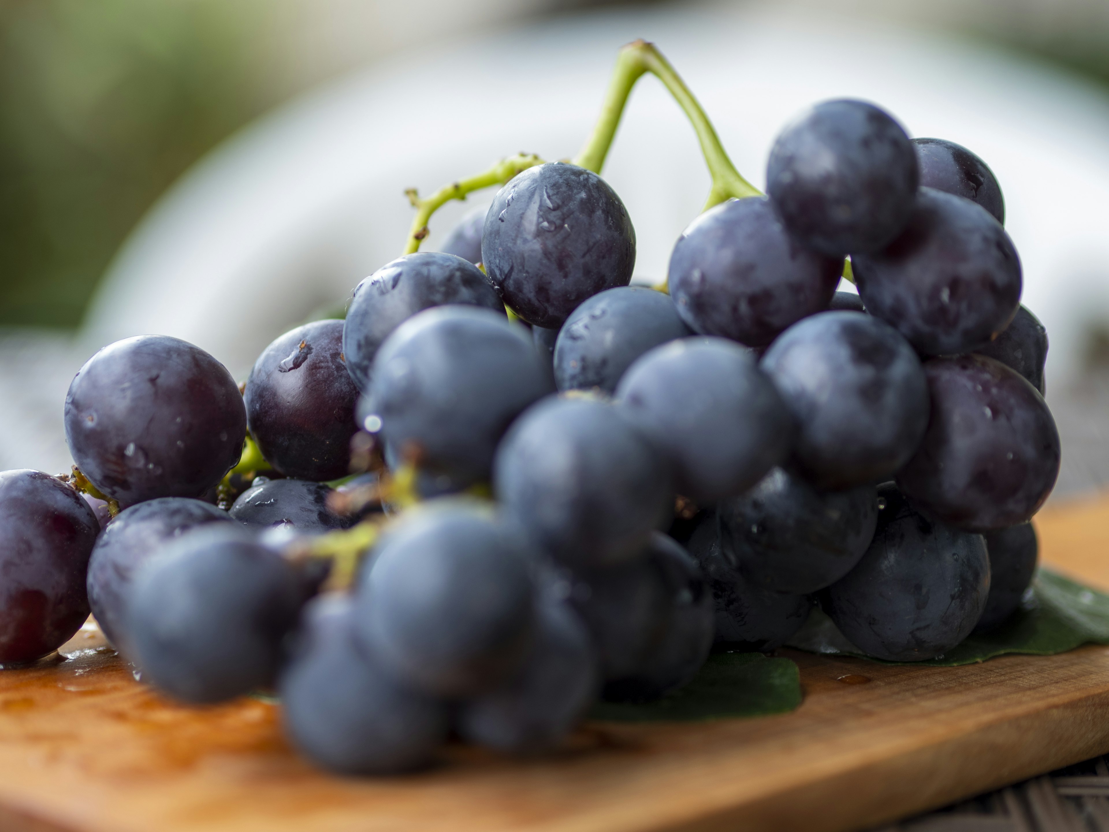 Un racimo de uvas frescas sobre una tabla de madera