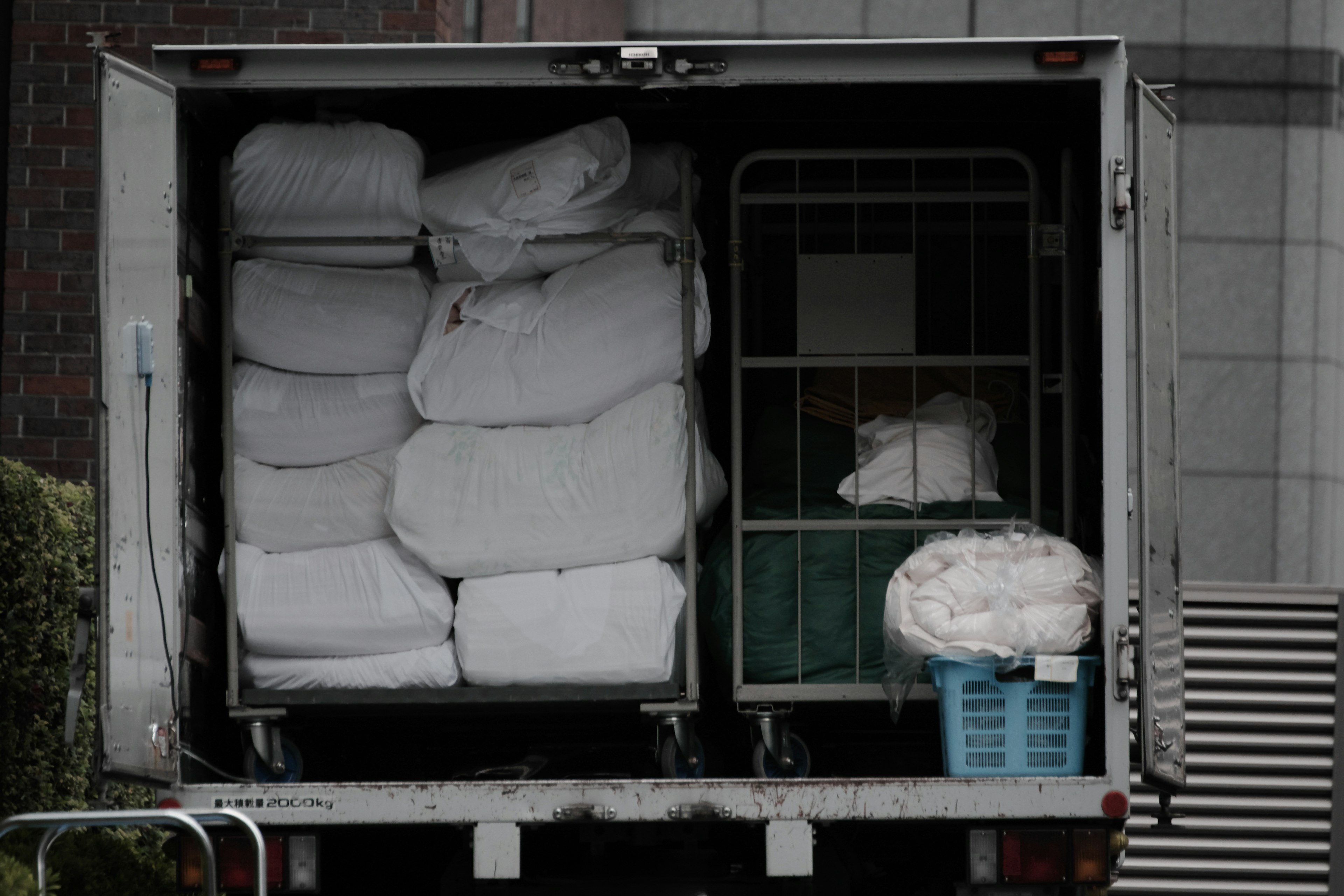 Truck bed filled with white blankets and a blue basket