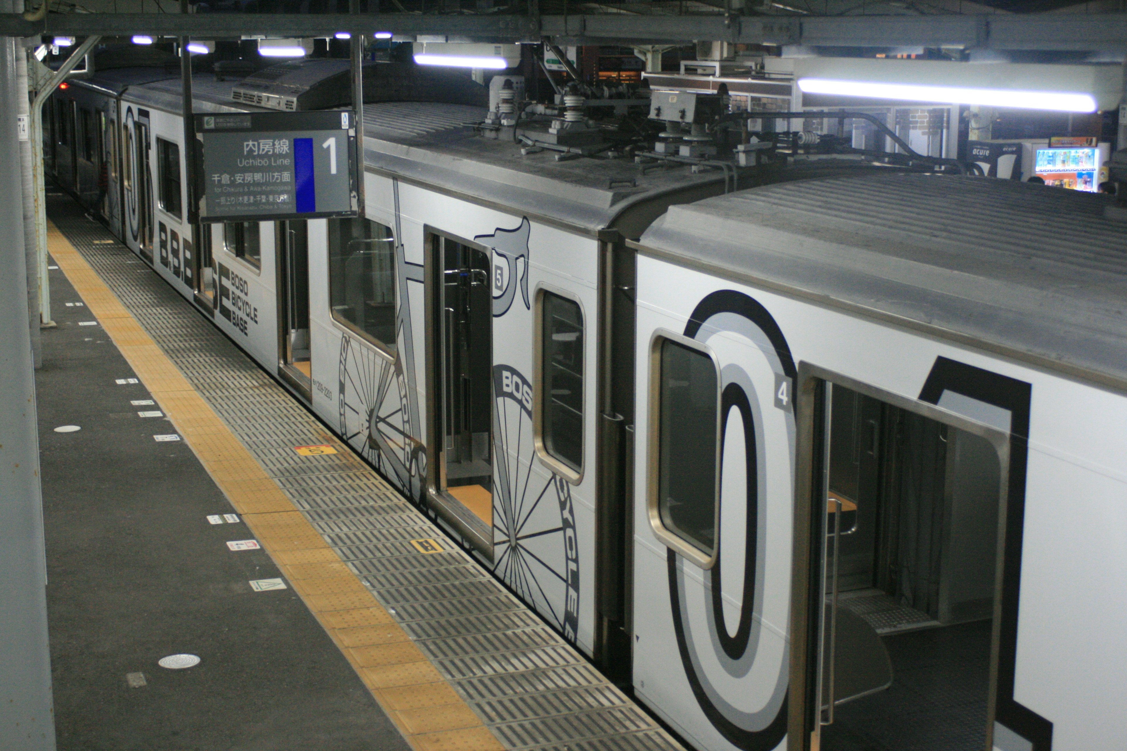 駅に停車しているデザインされた電車の側面に大きな数字が描かれている