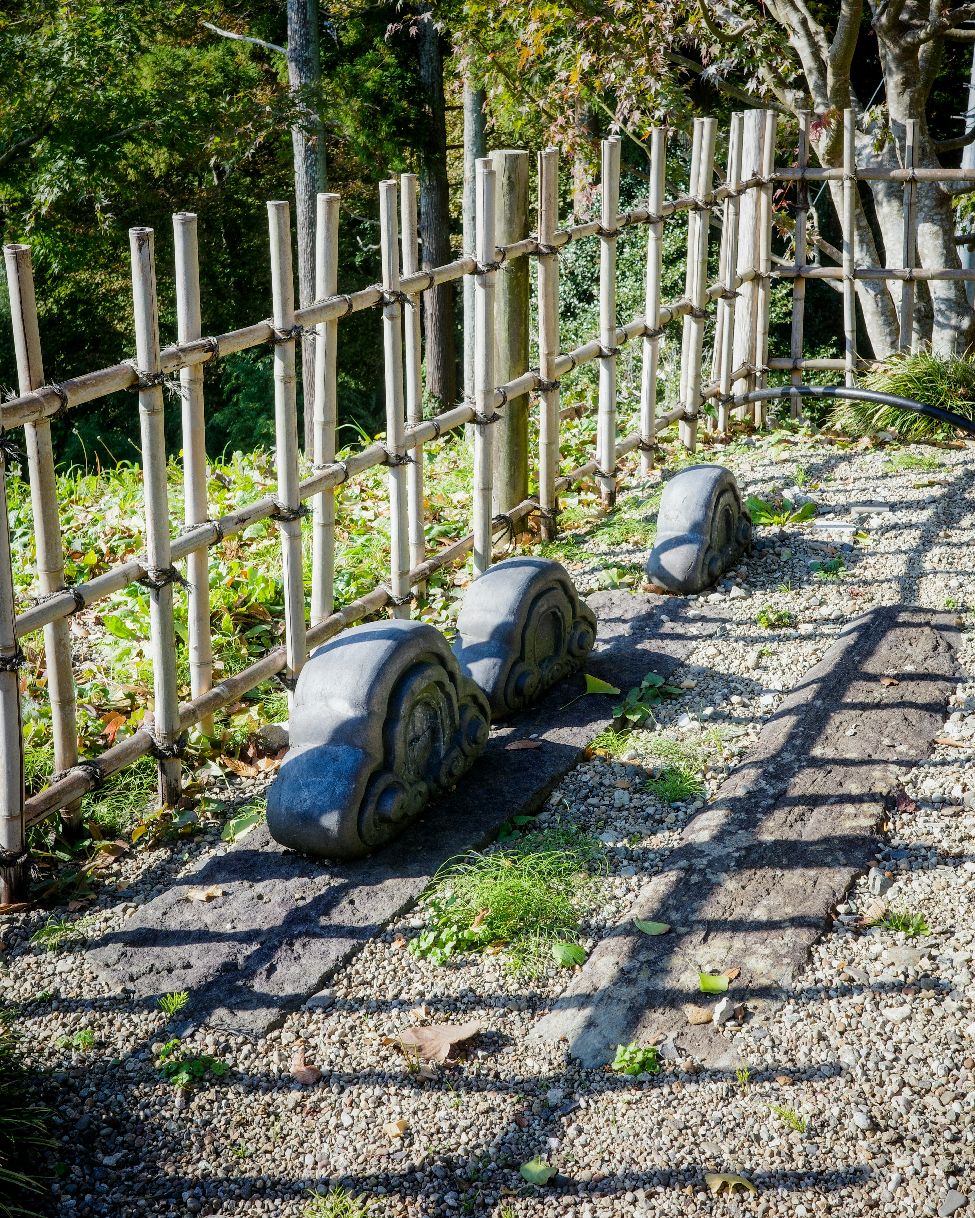 Sezione di giardino giapponese con recinzione in bambù e sentiero di pietra