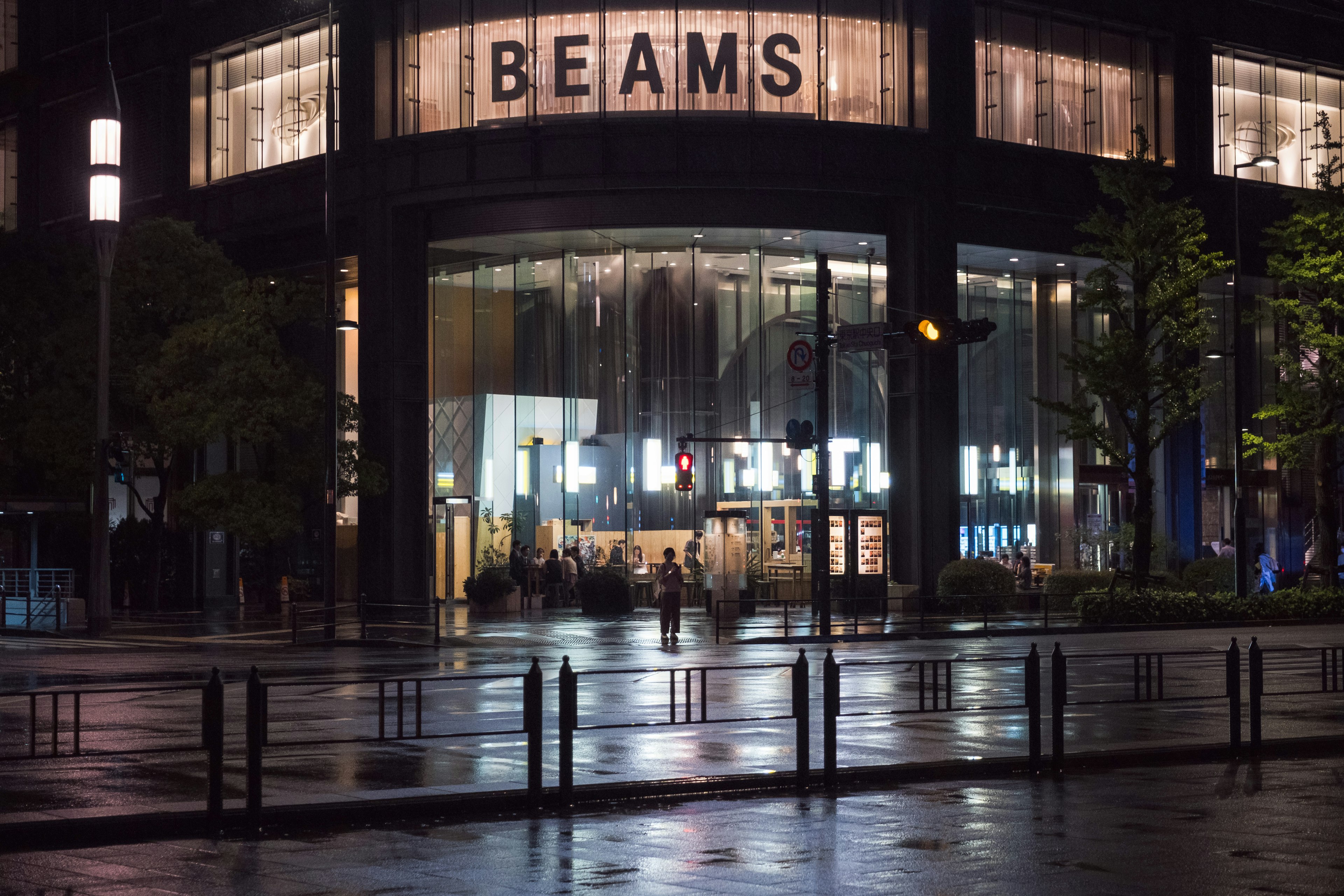 Vista nocturna de la tienda BEAMS con fachada de vidrio