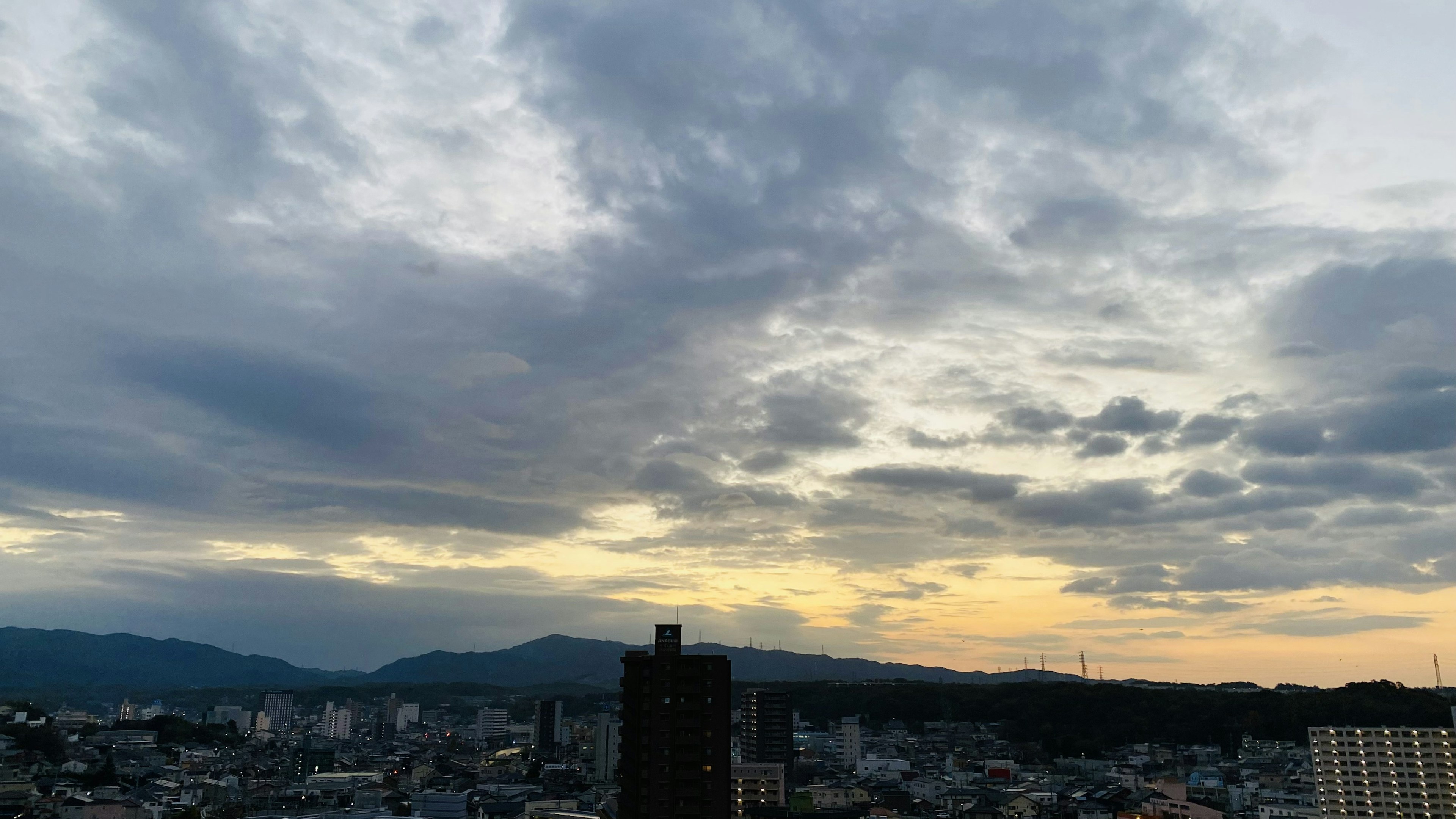 Bewölkter Himmel während des Sonnenuntergangs über einer Stadt