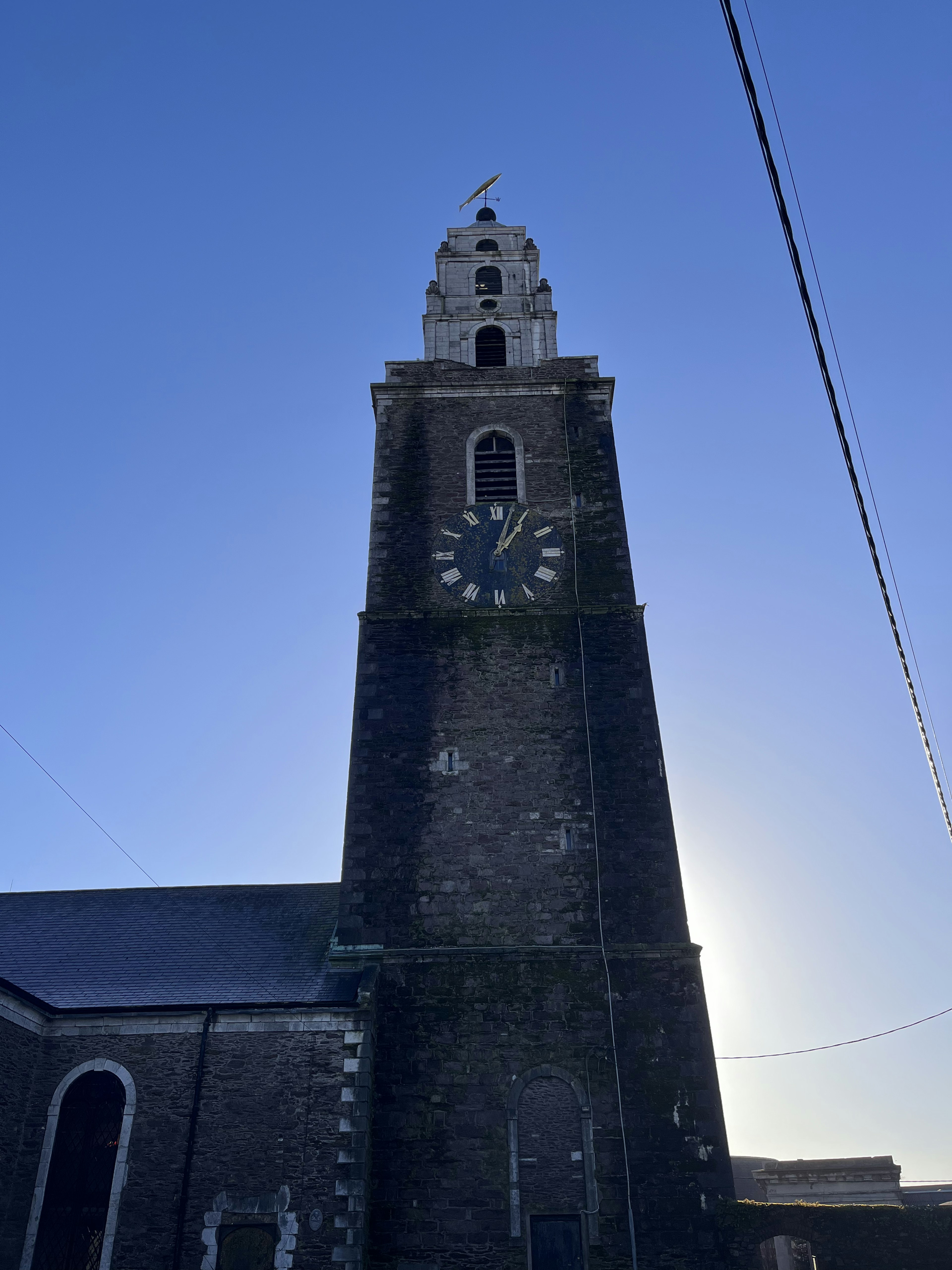 Hoher Kirchturm vor blauem Himmel