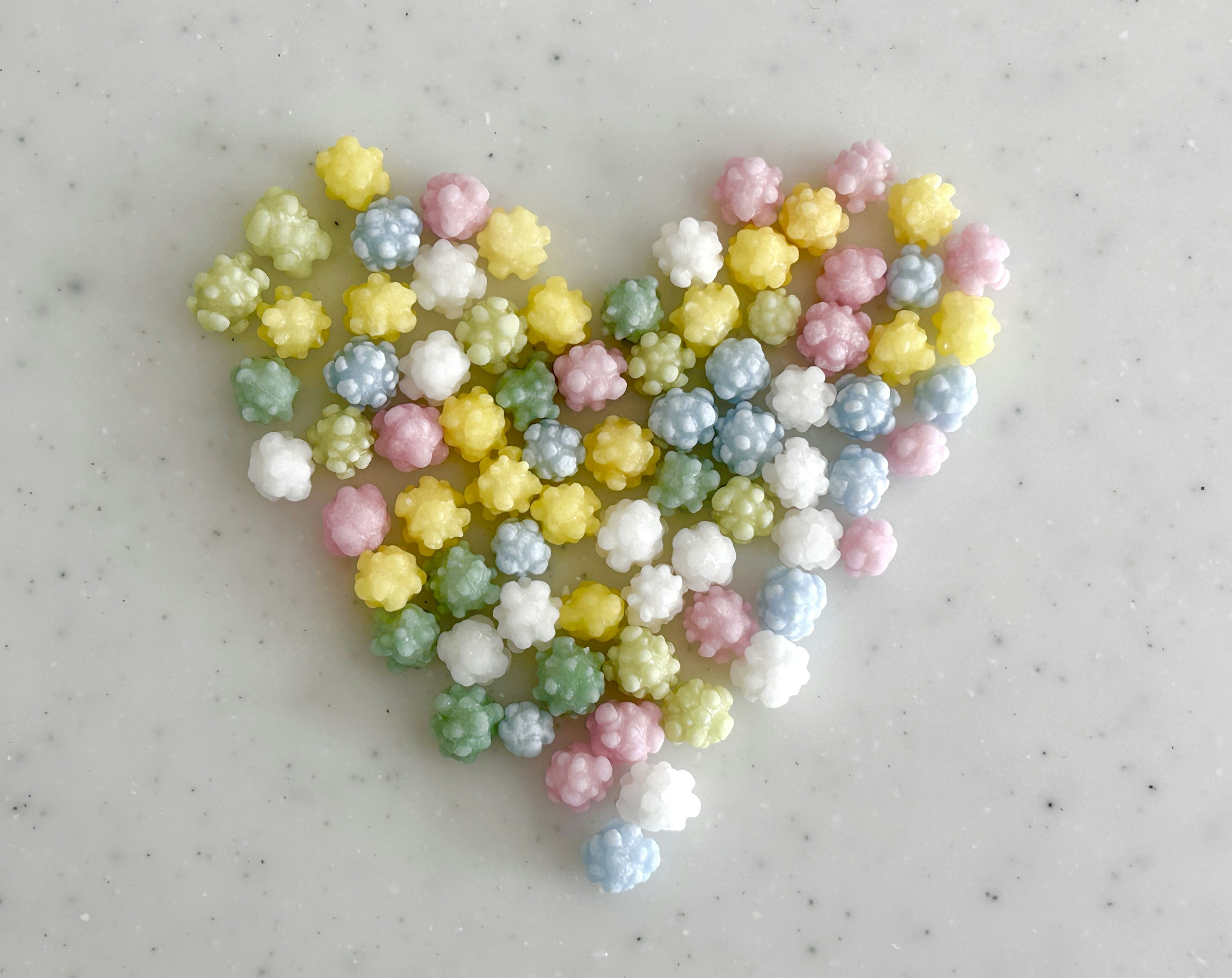 Colorful small spheres arranged in the shape of a heart