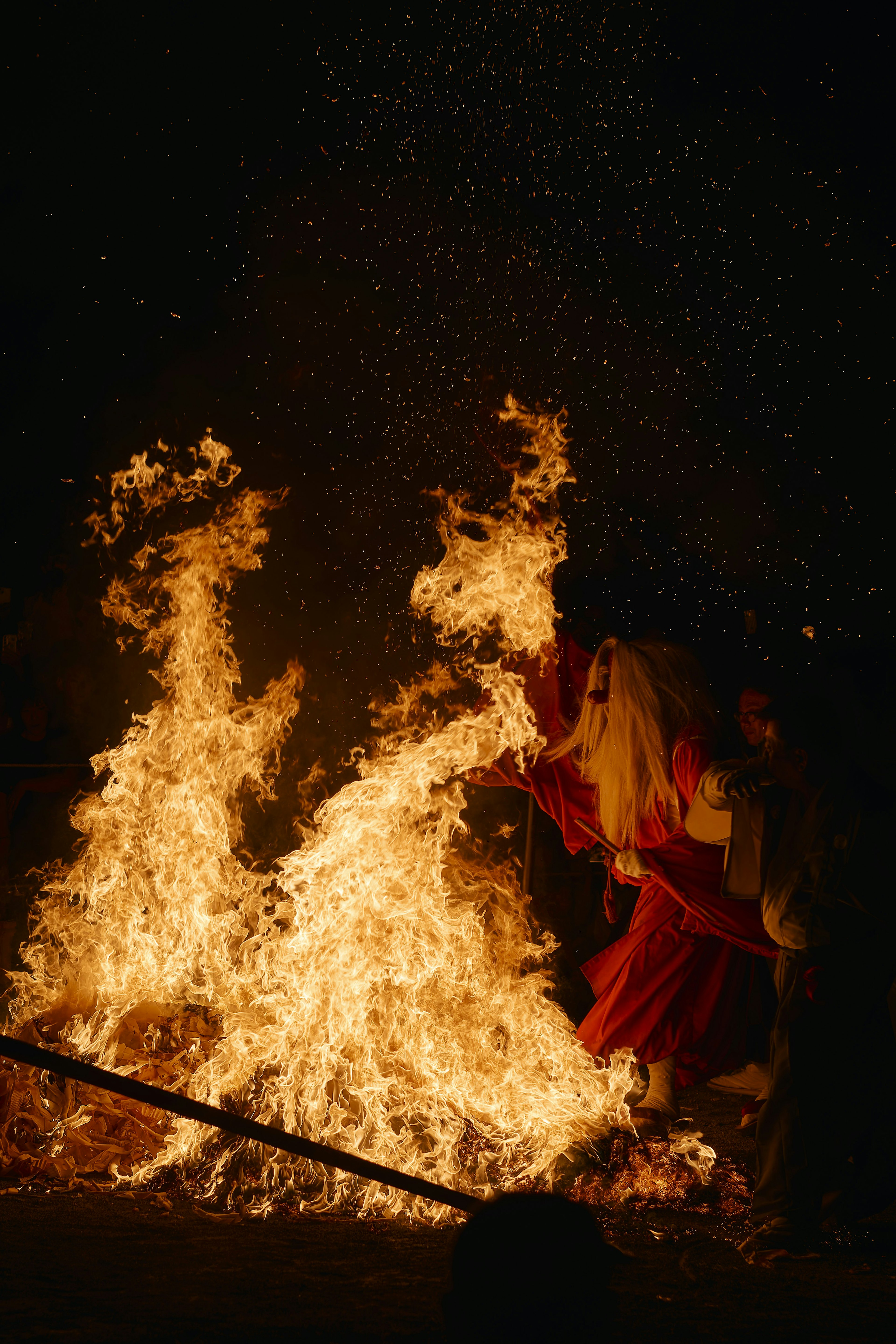 A person dancing in flames with sparks flying