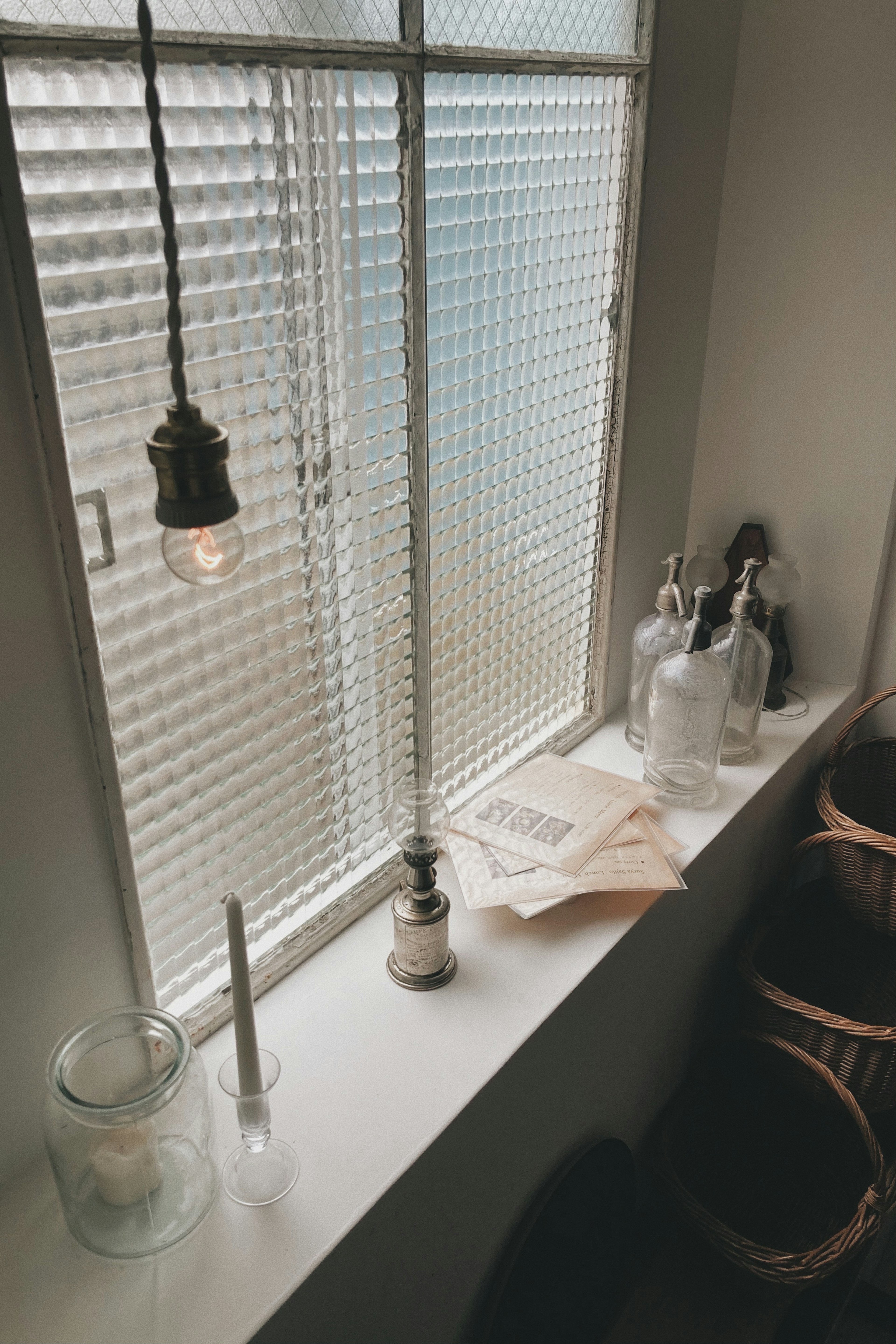 Simple indoor scene with glass containers and documents on a windowsill