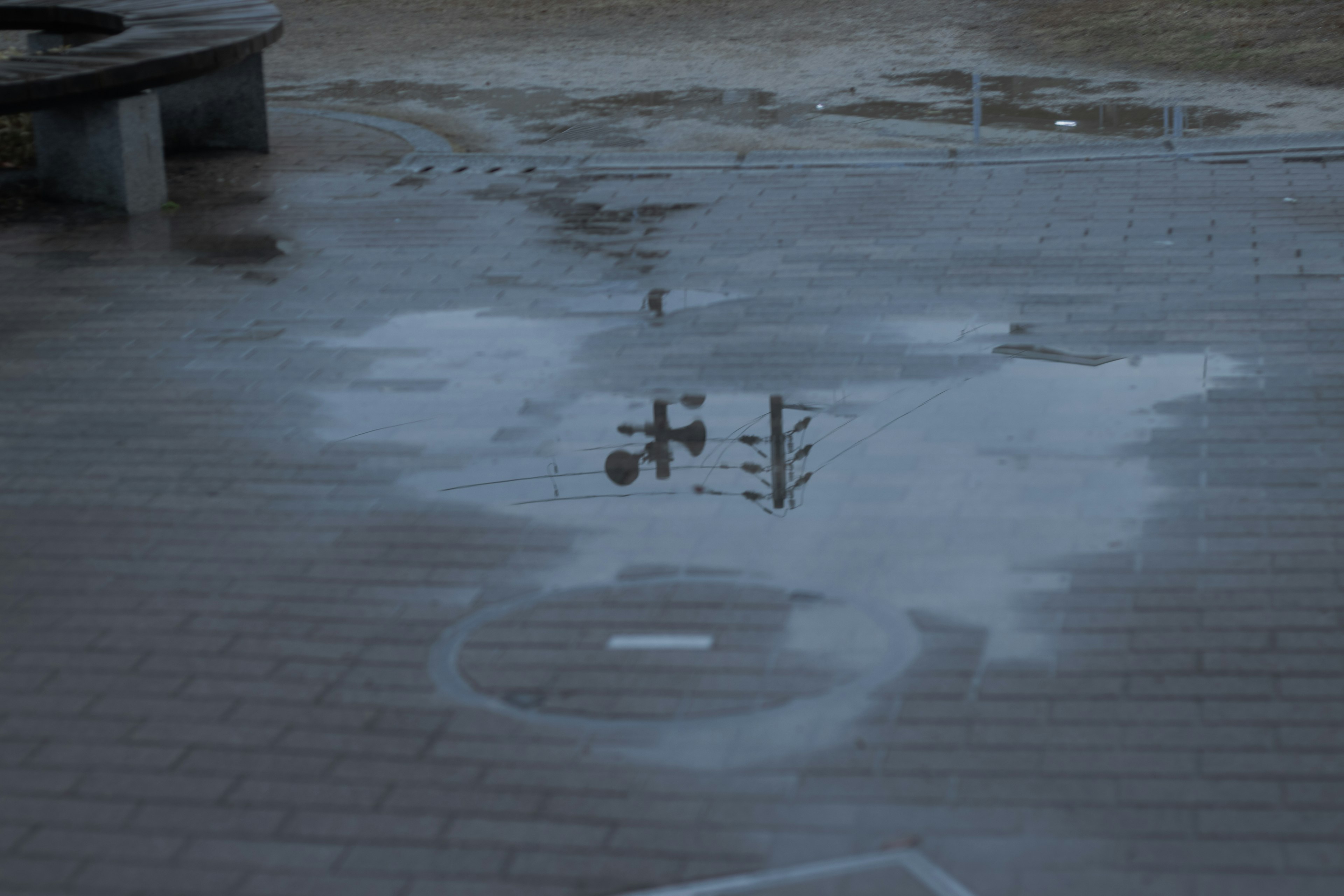 濡れた地面に映る信号機と水たまりの風景