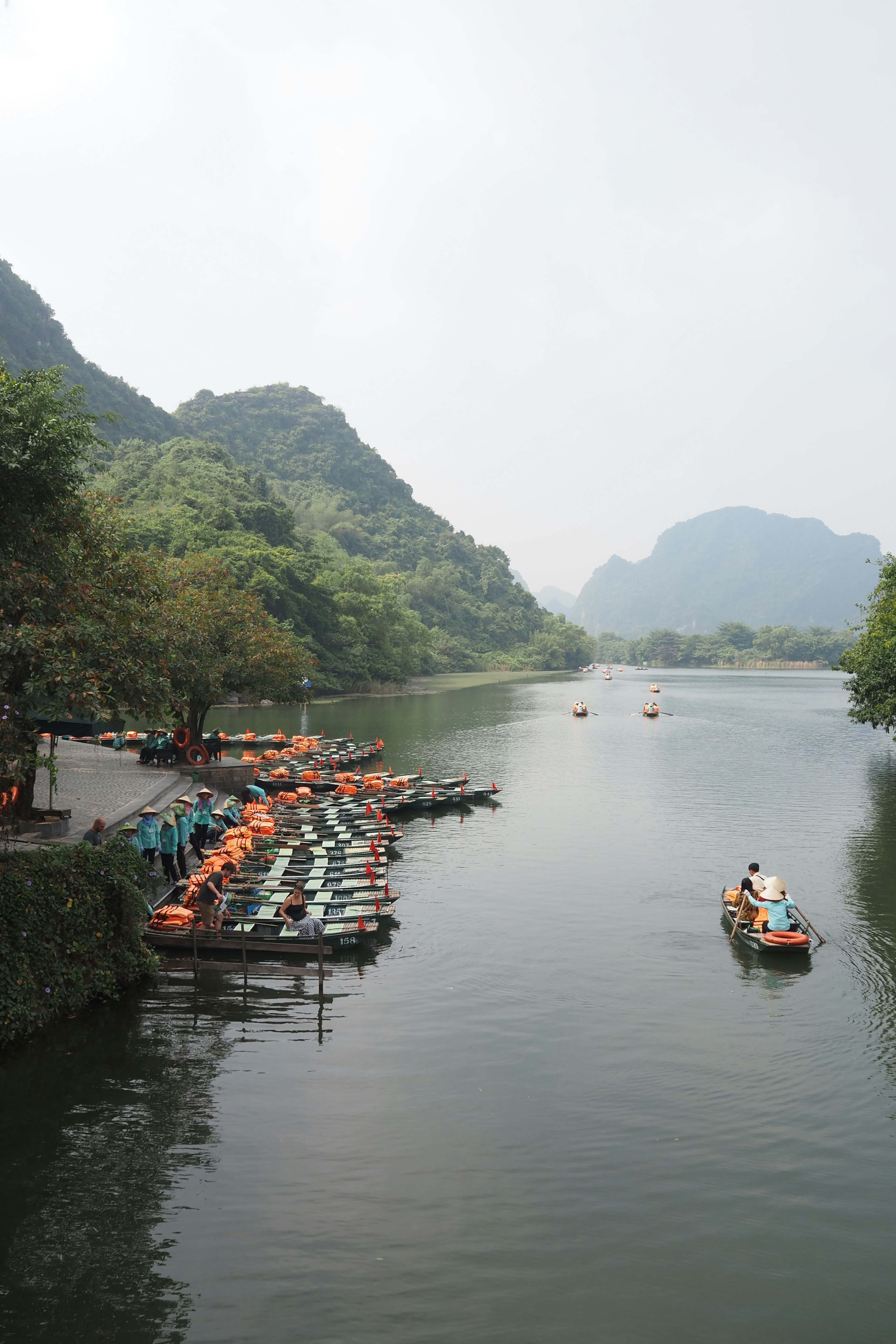 Rivière sereine avec de petits bateaux et montagnes environnantes