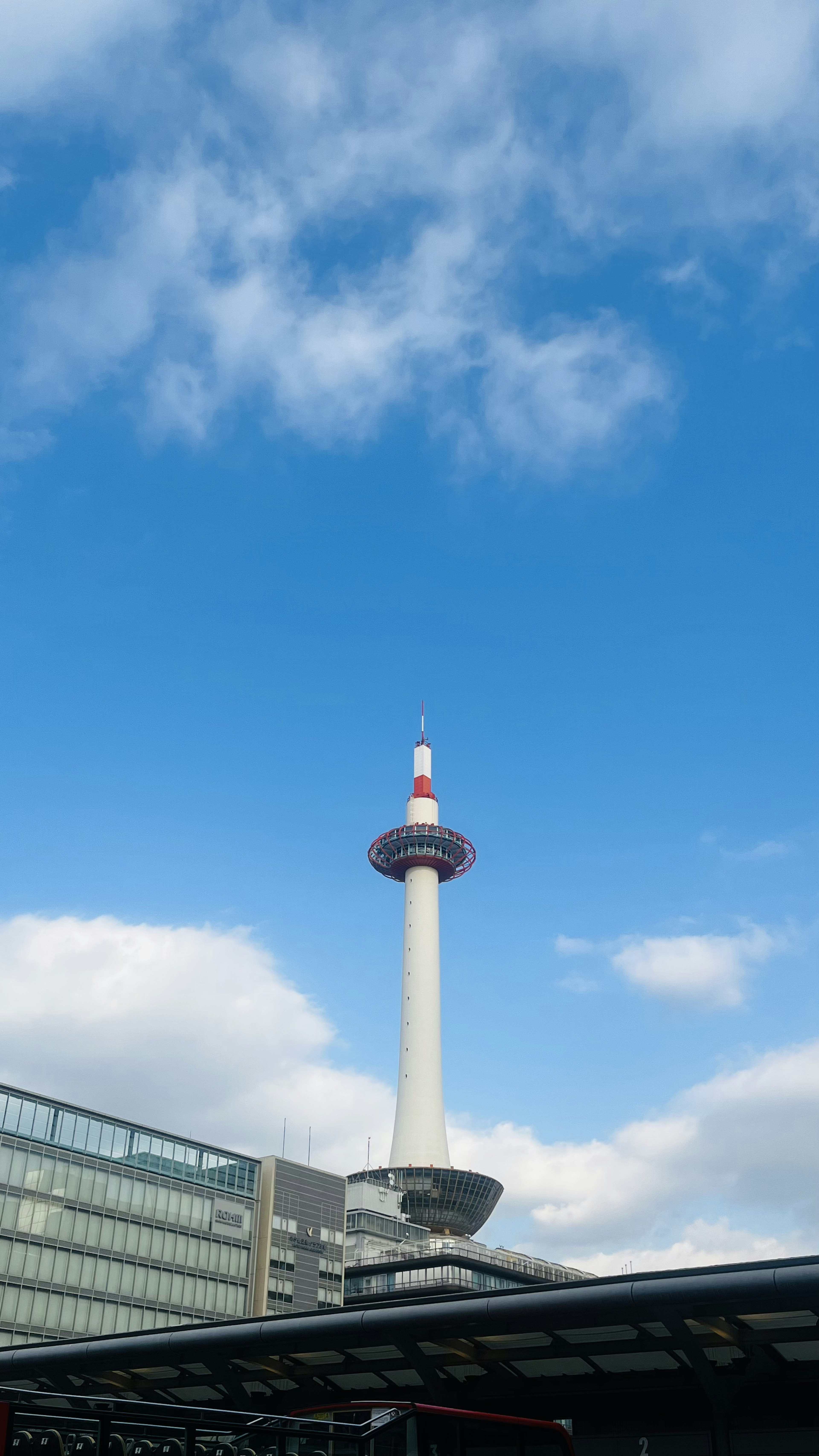 青空の下にそびえるタワーと現代的な建物の風景