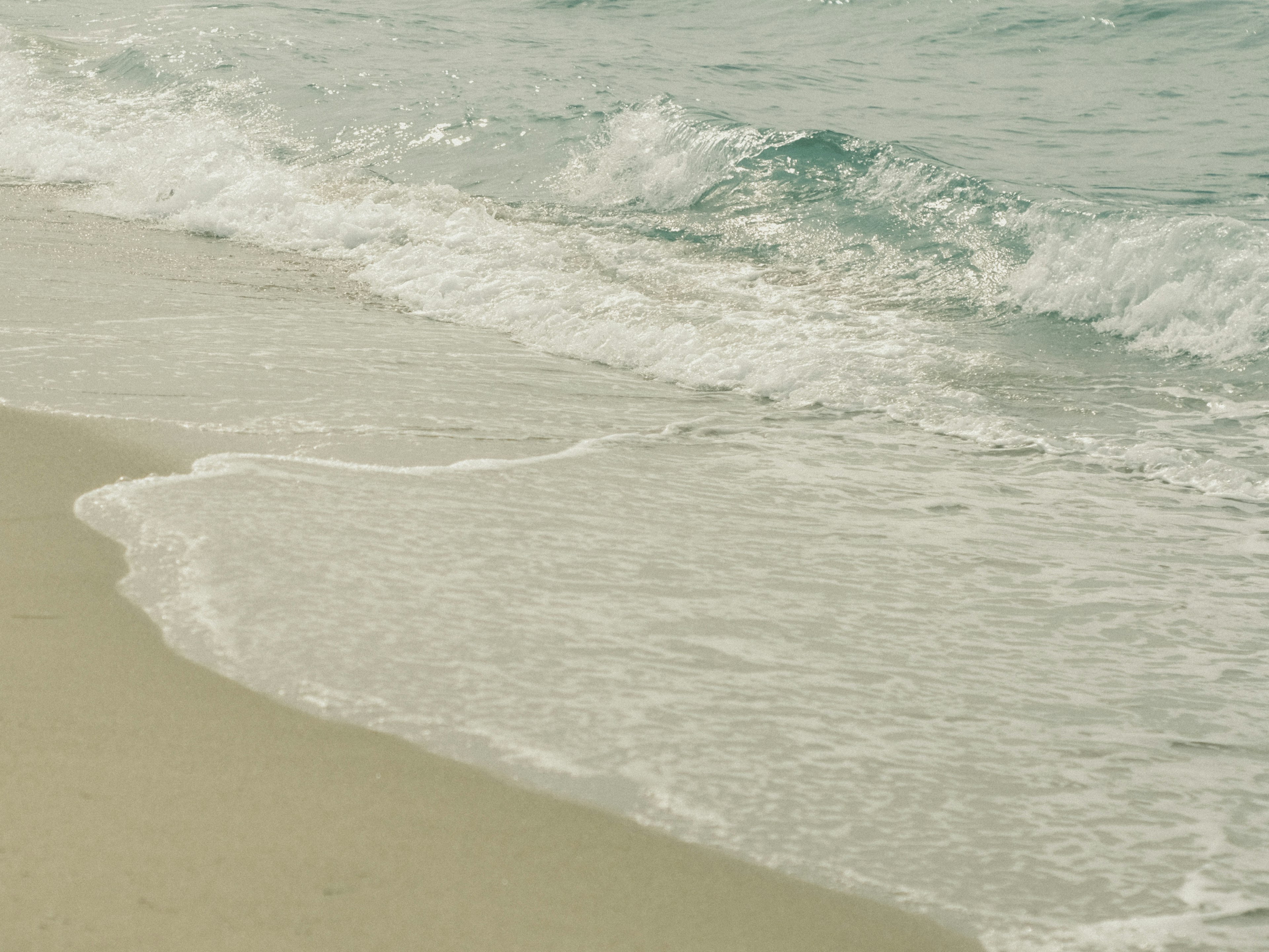 Onde calme che si infrangono su una spiaggia sabbiosa