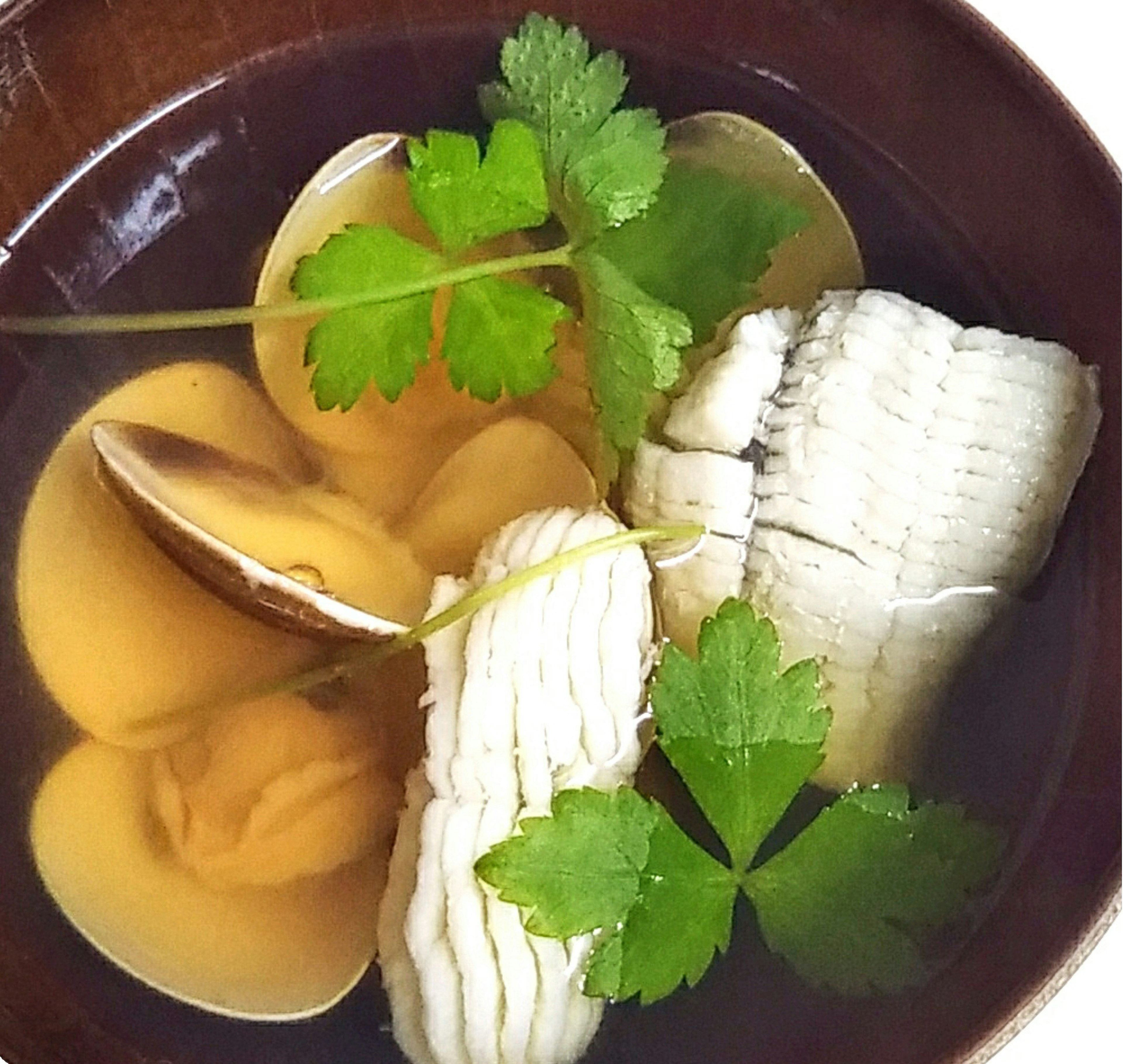 Soupe avec du poisson blanc et des palourdes garnie de coriandre